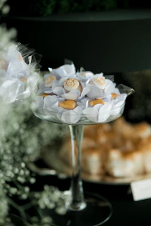 Elegant white and gold candies in a glass dish.