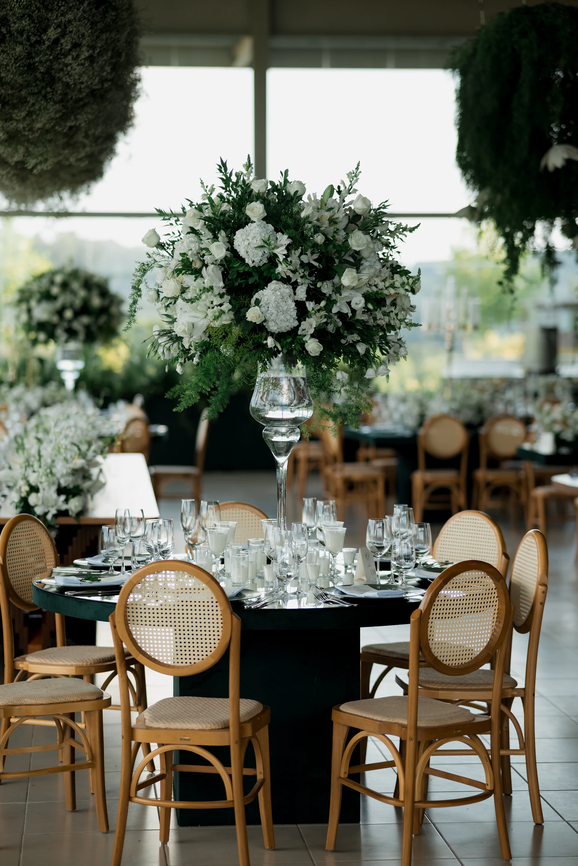 Elegant wedding reception table with floral centerpiece and chairs
