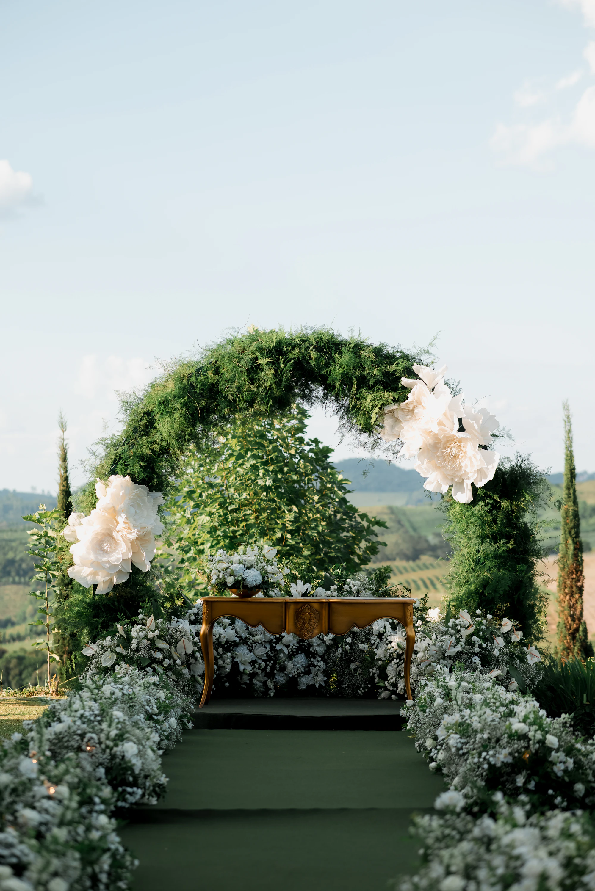 Outdoor wedding ceremony arch, floral decor and white flowers in a natural setting