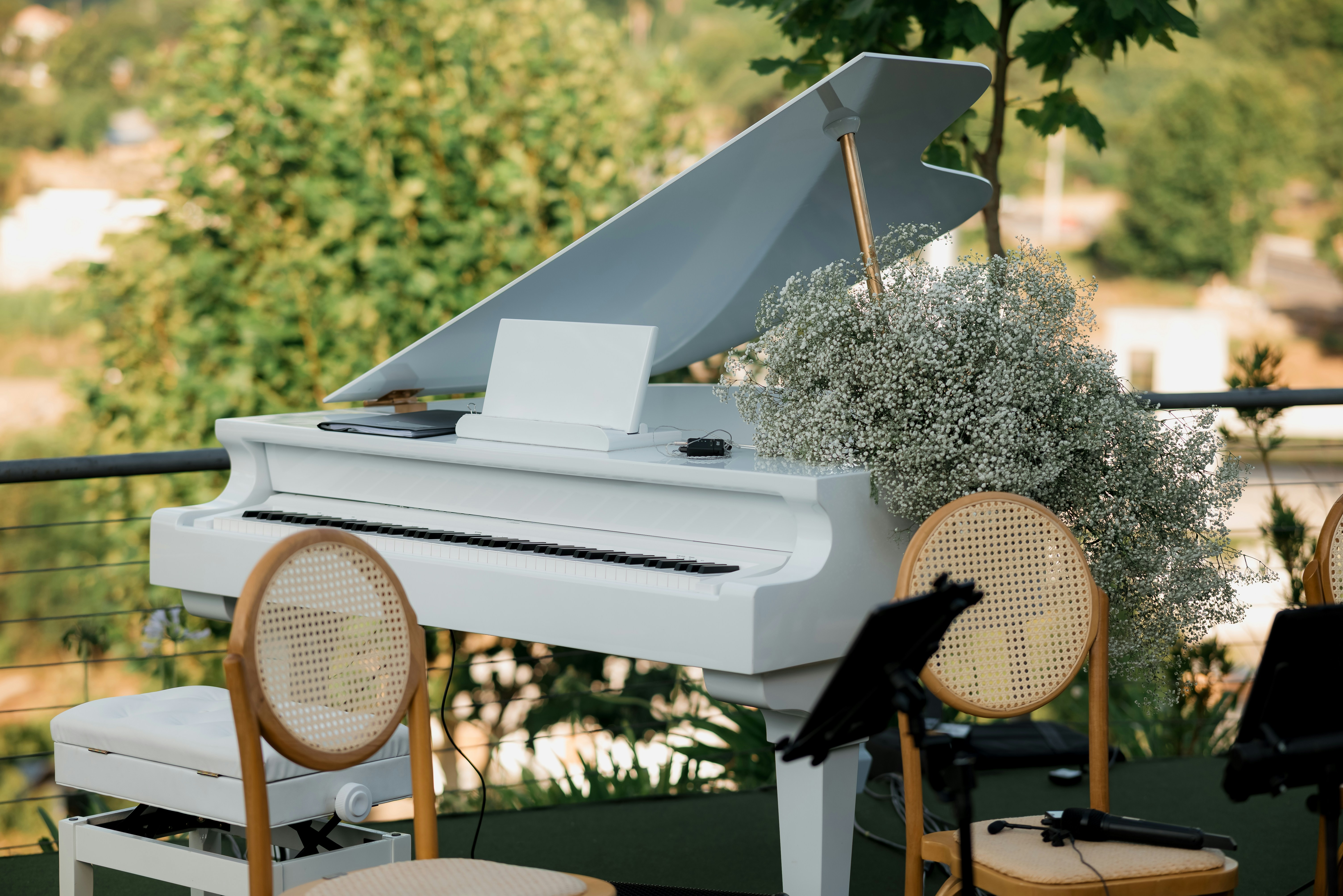 屋外には白いグランドピアノがあり、花のアレンジメントが飾られています。