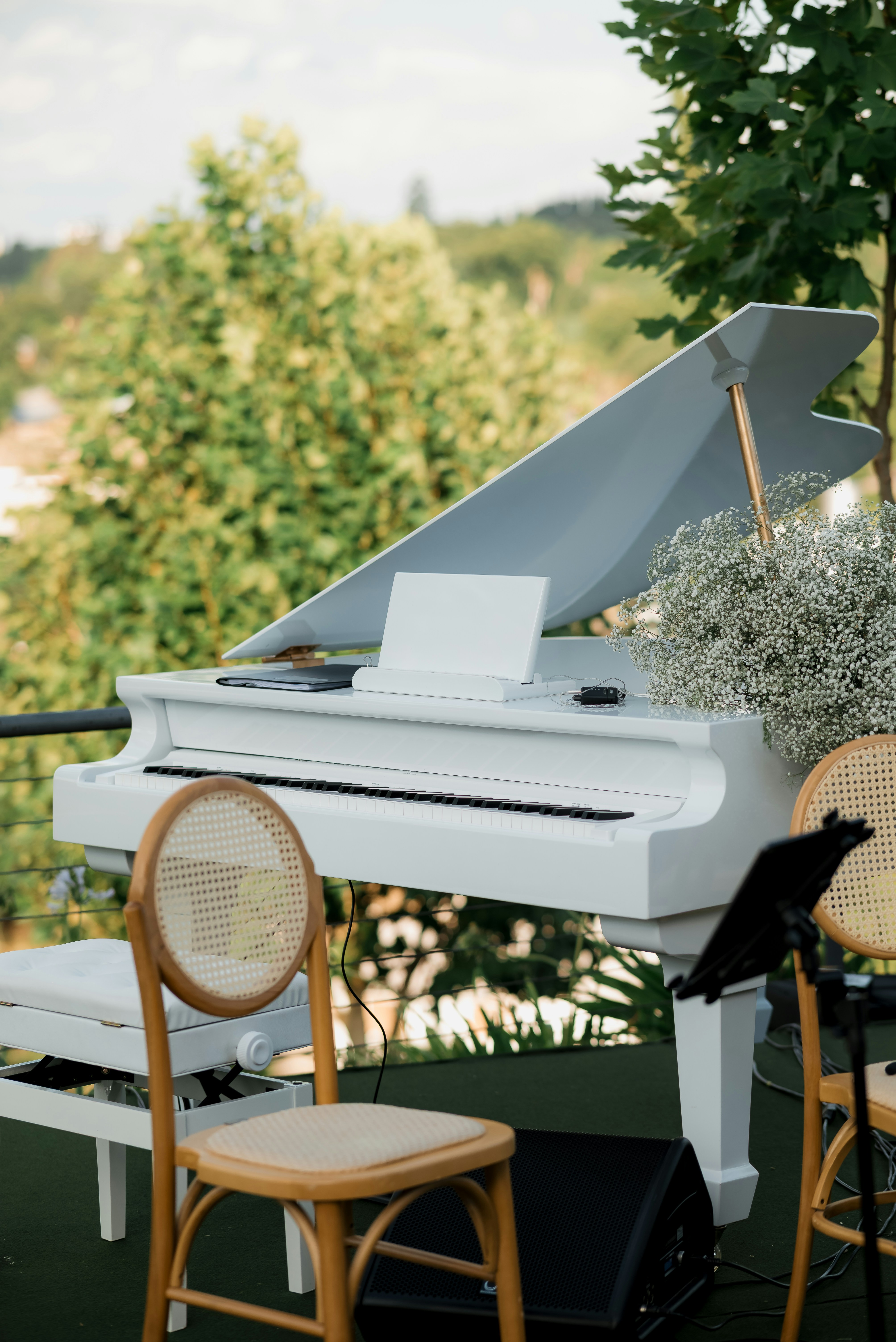 屋外ステージに白いグランドピアノが置かれている