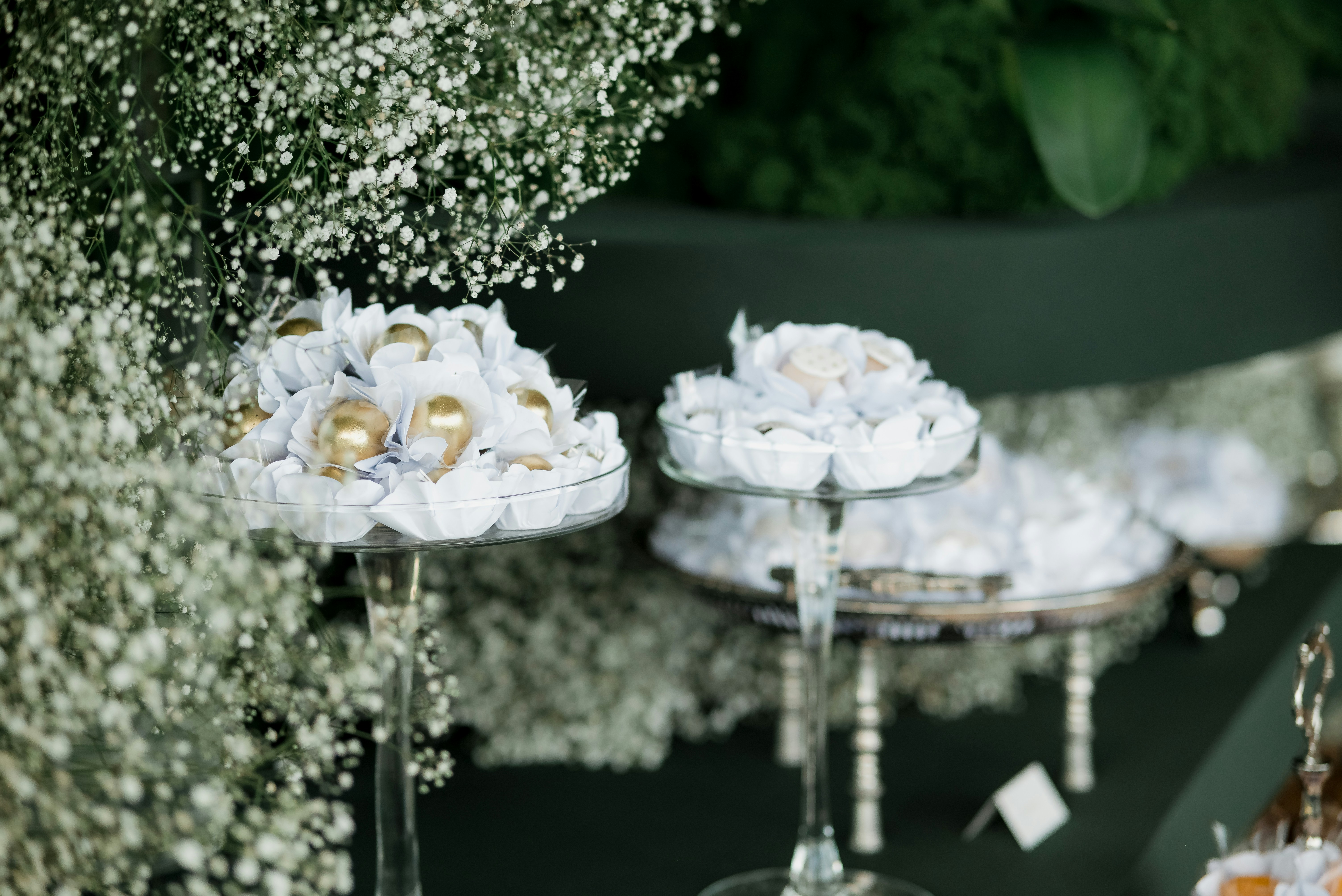 Des douceurs élégantes exposées sur des supports à étages décorés de fleurs.