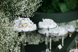 Elegant sweets displayed on tiered stands with floral decor.