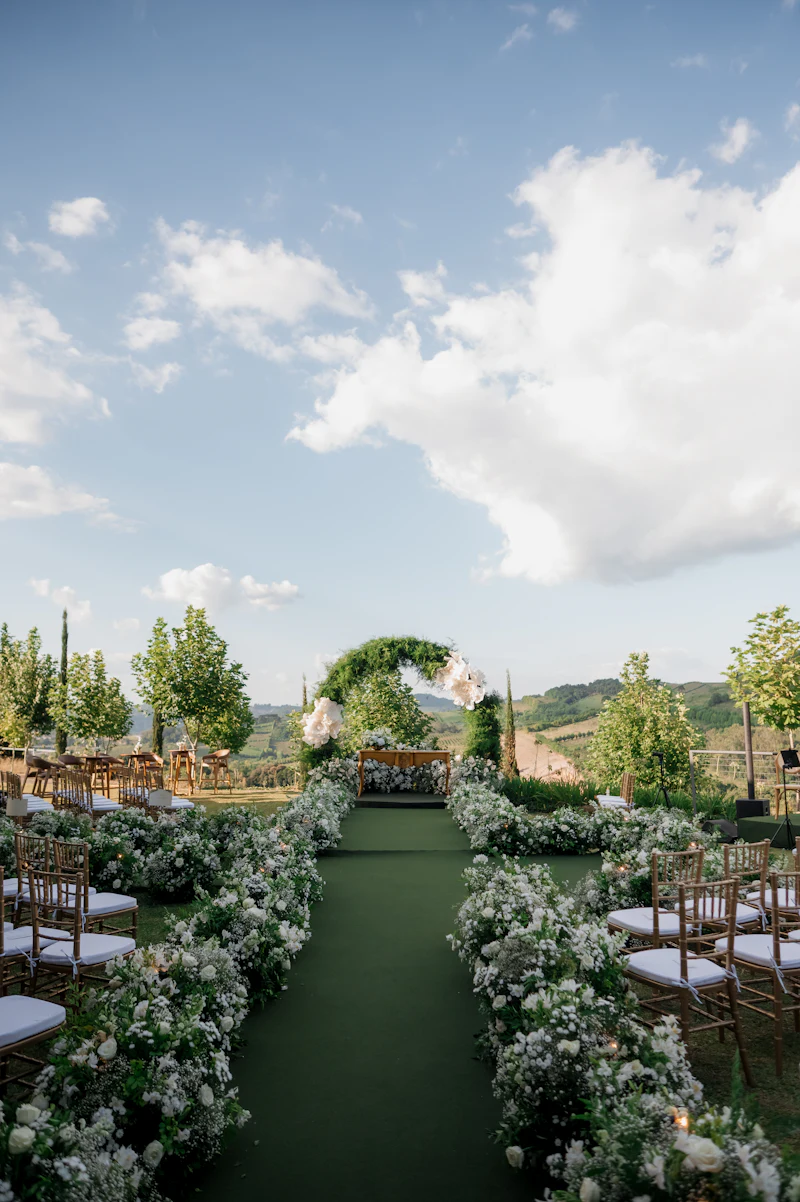 A floral arch and aisle set for a wedding on the estate lawn
