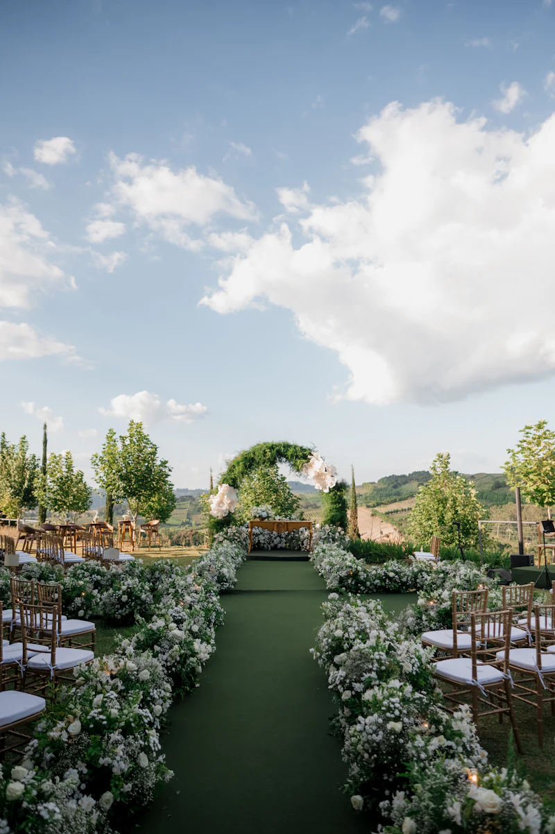 A floral arch and aisle set for a wedding on the estate lawn