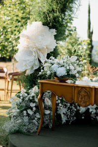 Elegant outdoor wedding decor with flowers and ornate table.