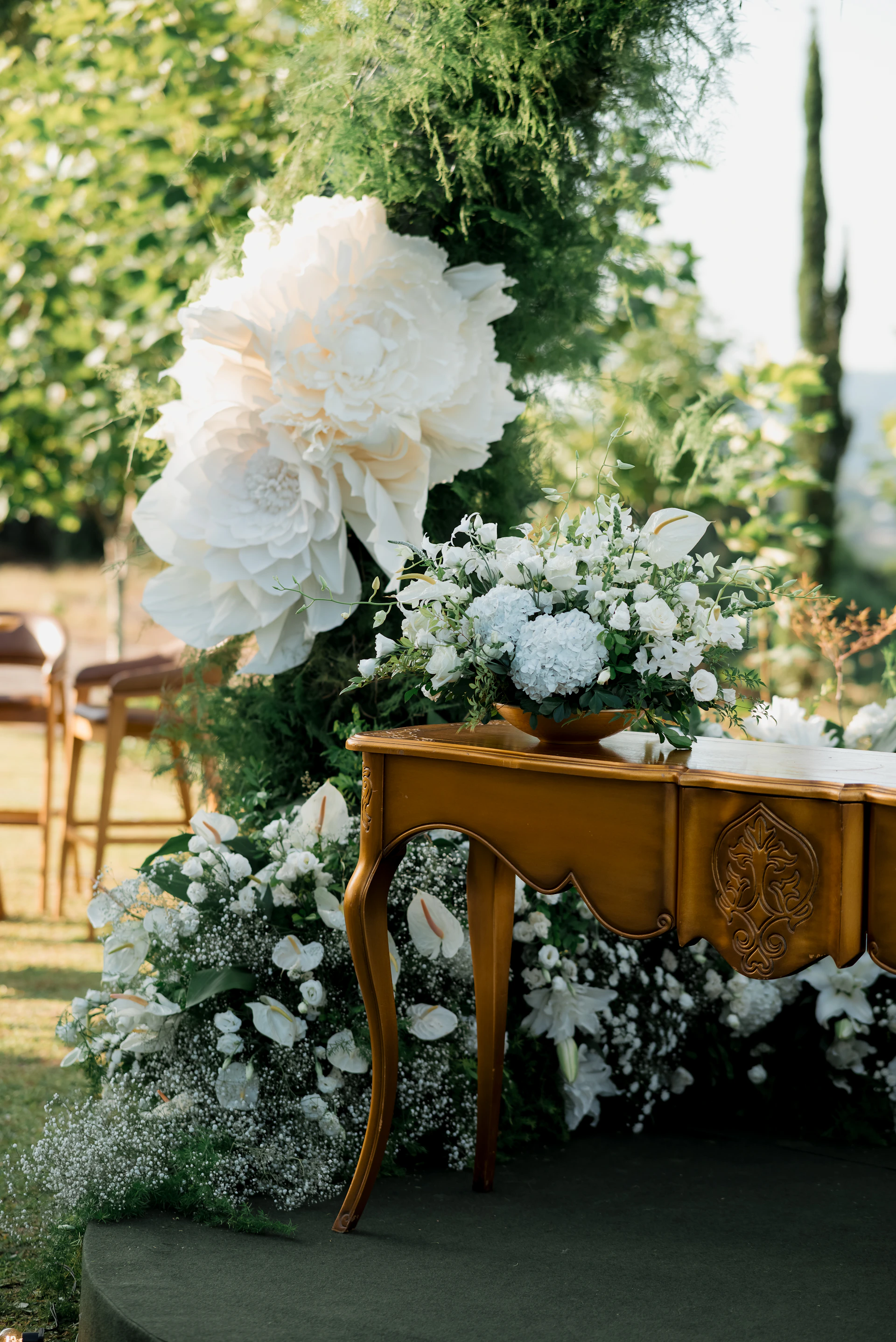 Elegant outdoor wedding decor with flowers and ornate table.