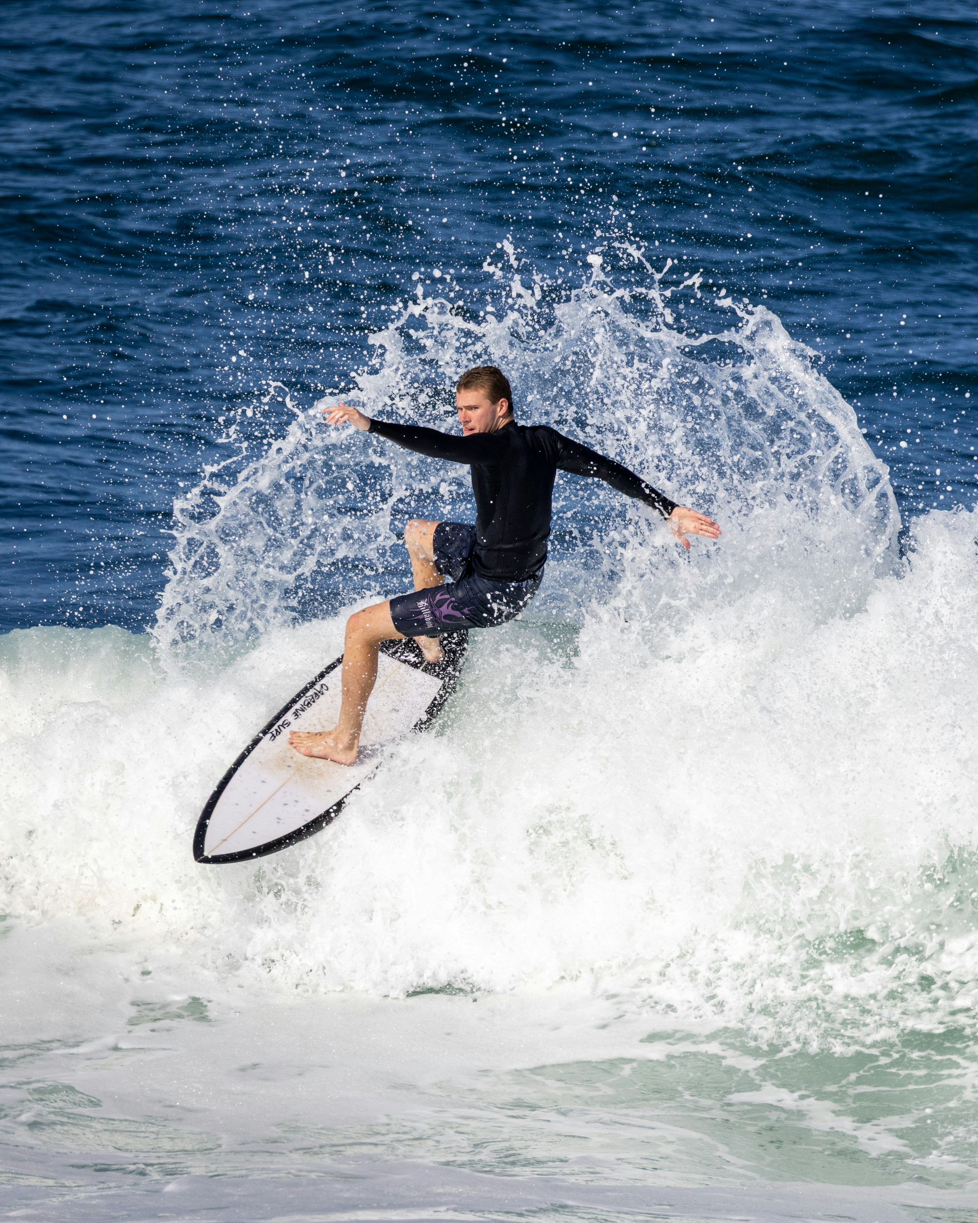 Surfer riding a wave with spray in the air