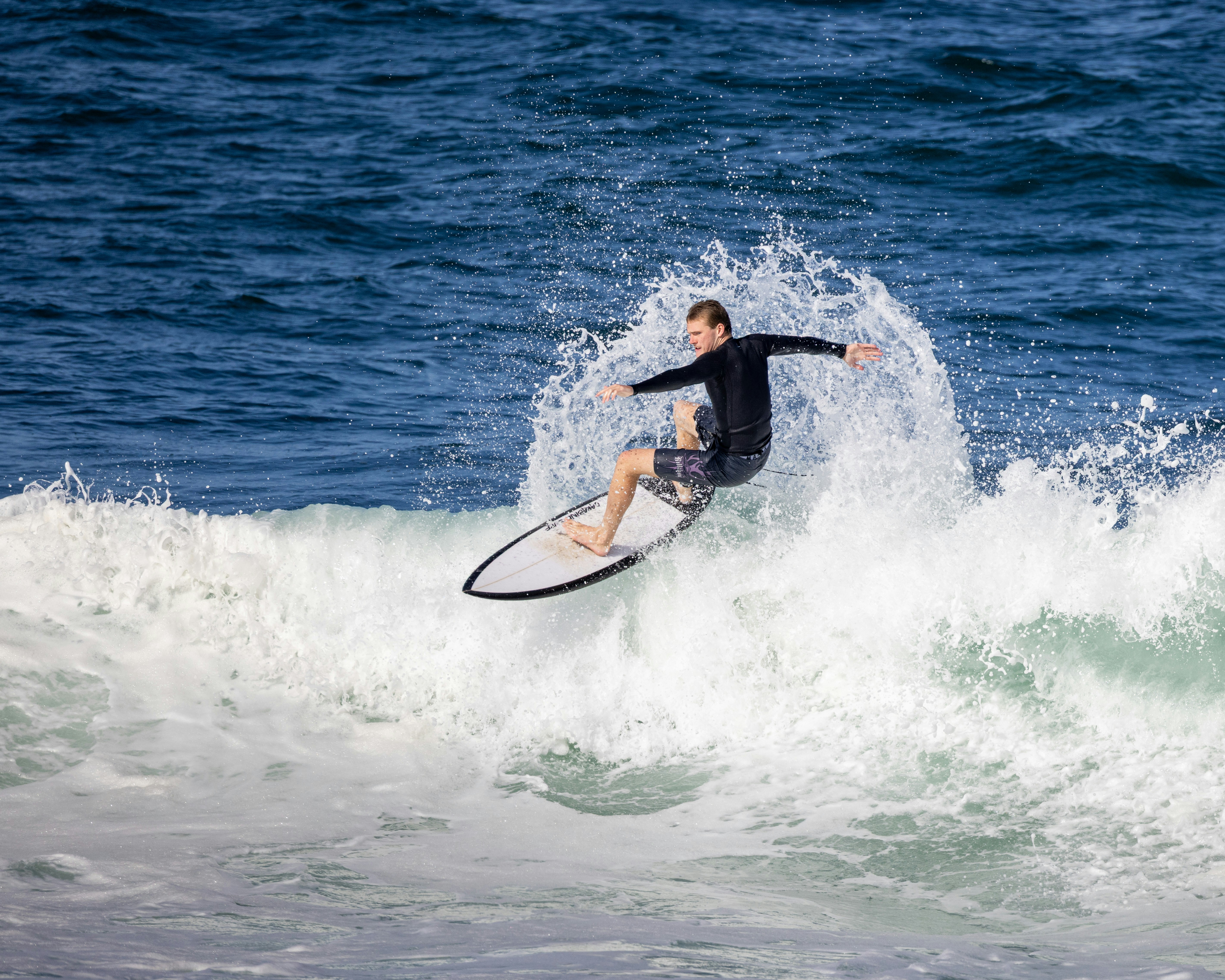 Surfer riding a wave with water splashing