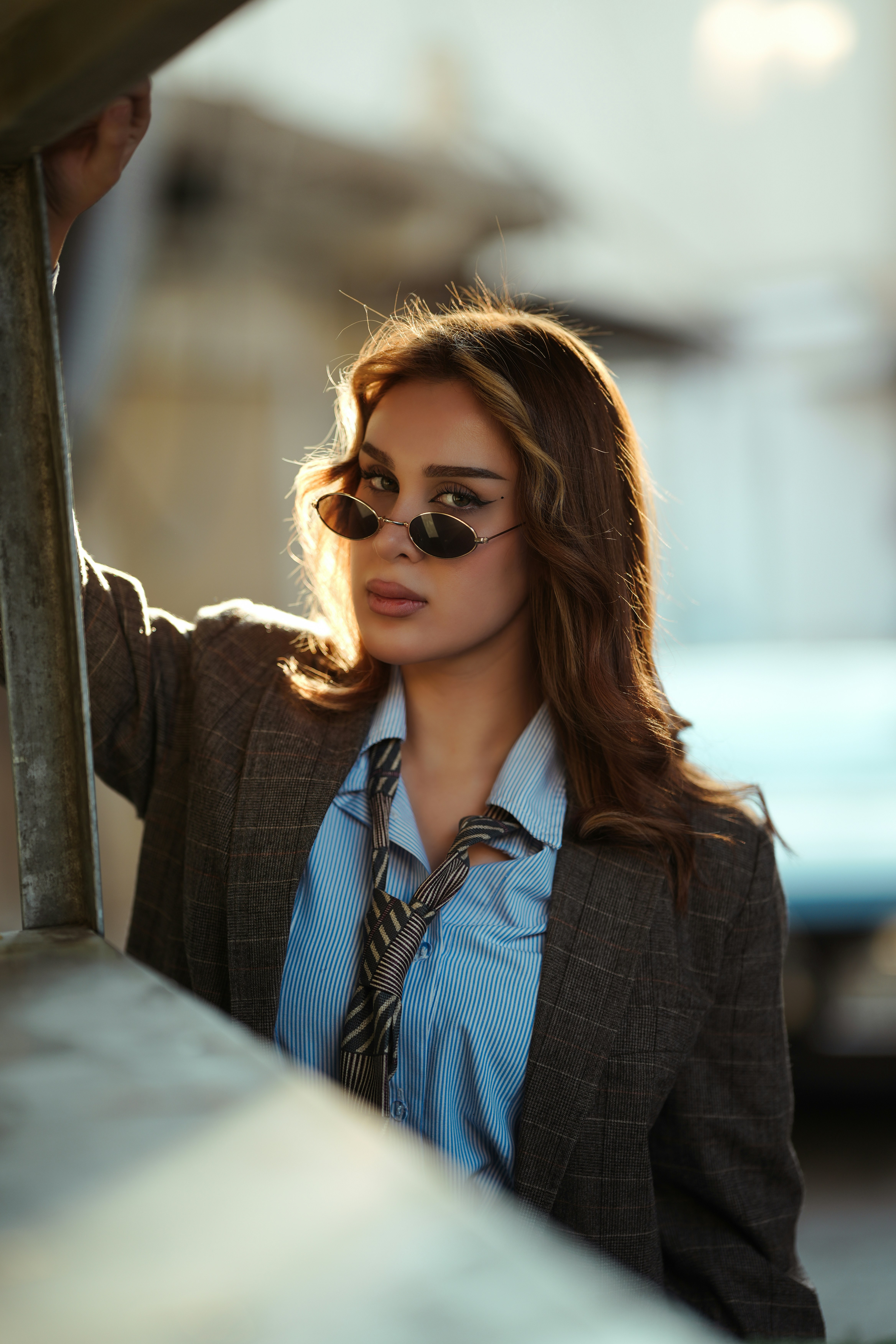 Woman in sunglasses and blazer looking at camera