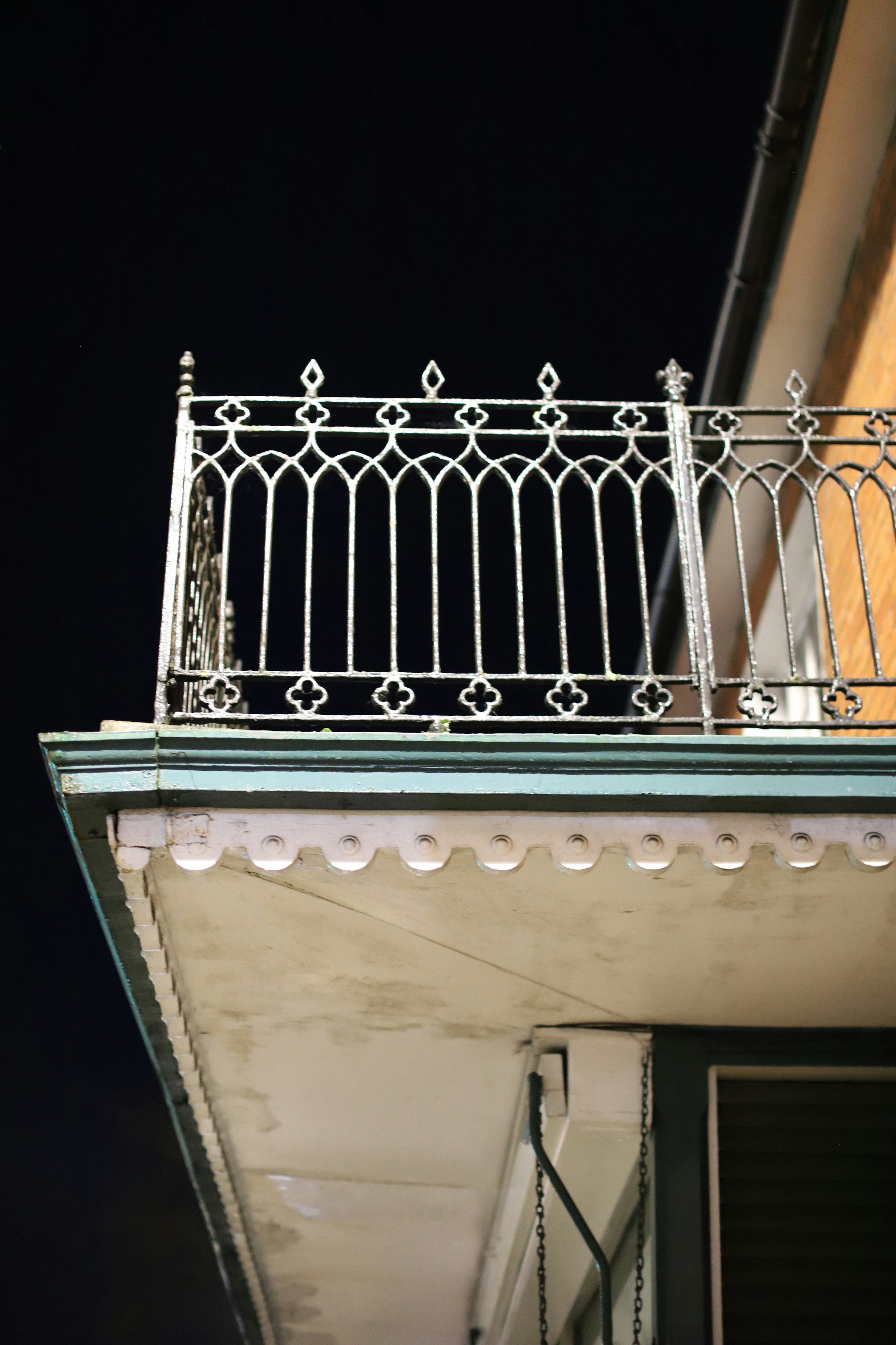 Ornate wrought iron balcony railing against dark sky