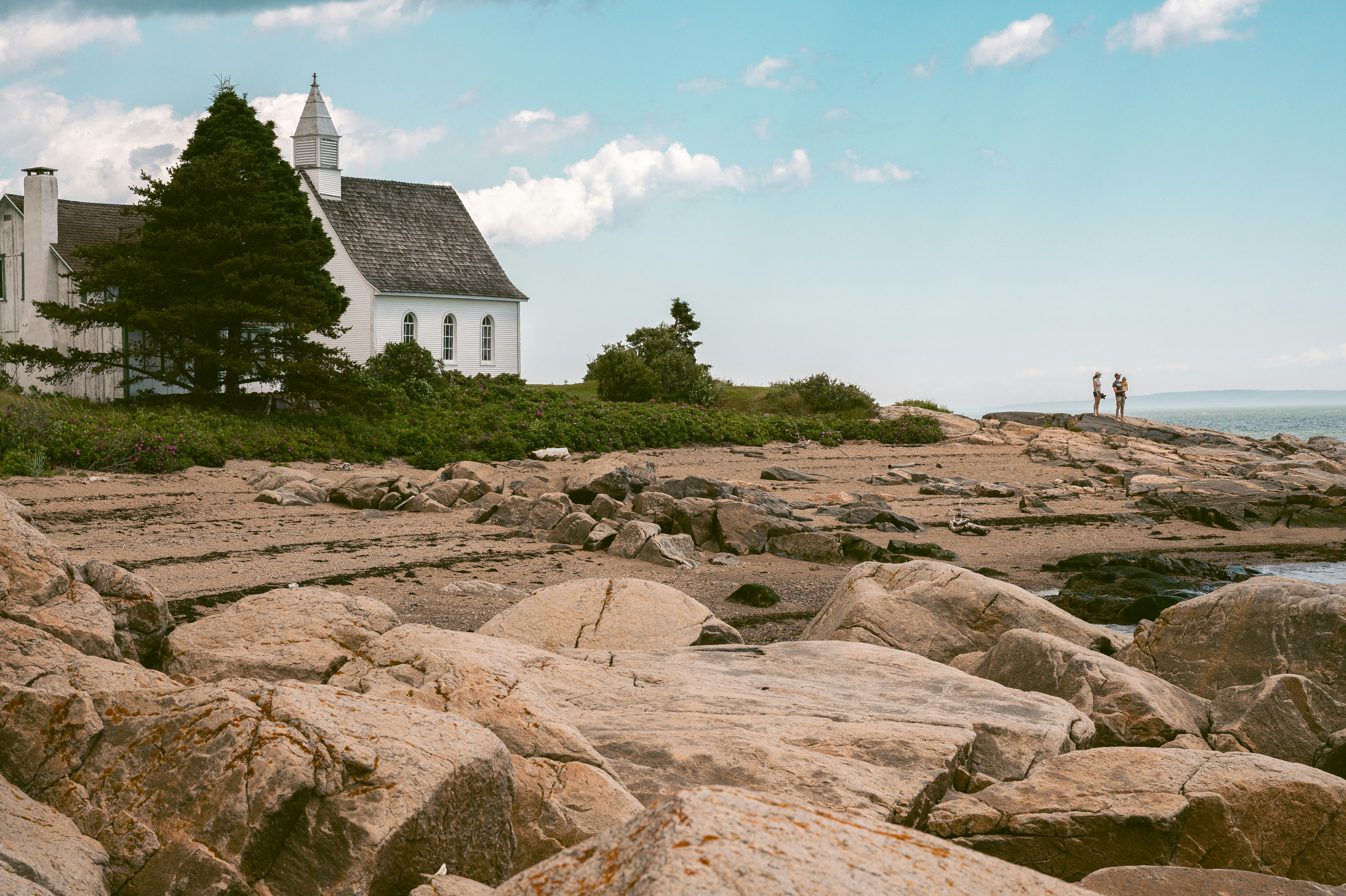 White church on rocky coast with ocean background