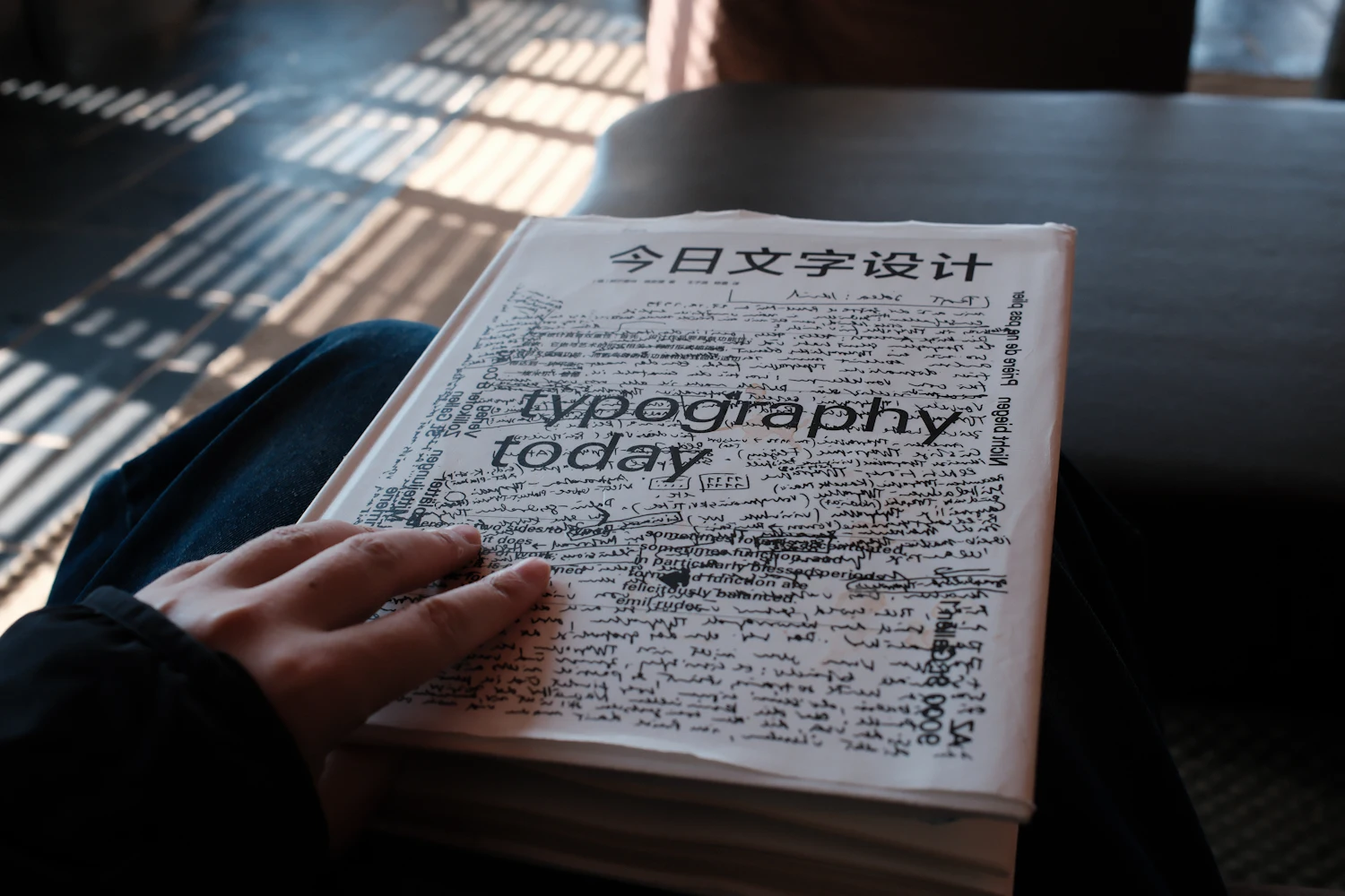 A person holding a book titled "typography today"