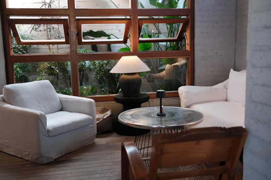 Zona de espera com poltronas cor de creme e plantas junto à janela