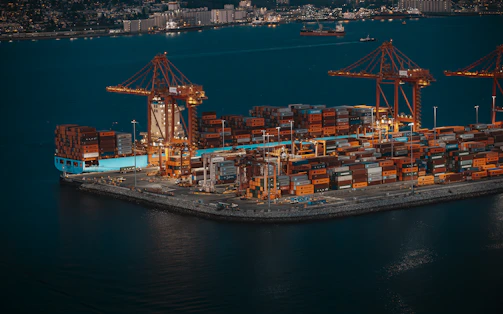 Container ship and cranes at a busy shipping port.