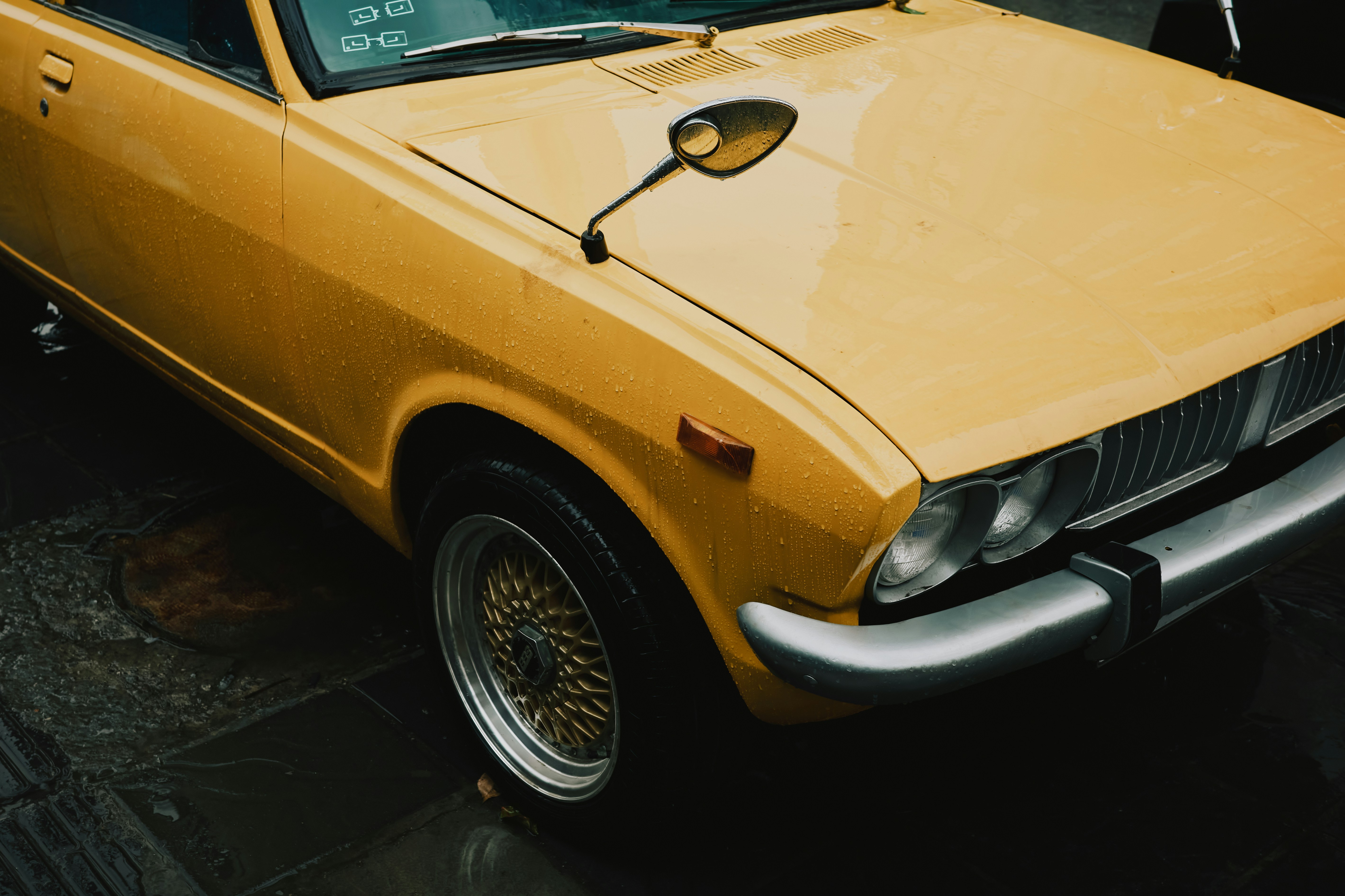 クロームのアクセントが施されたヴィンテージイエローの車