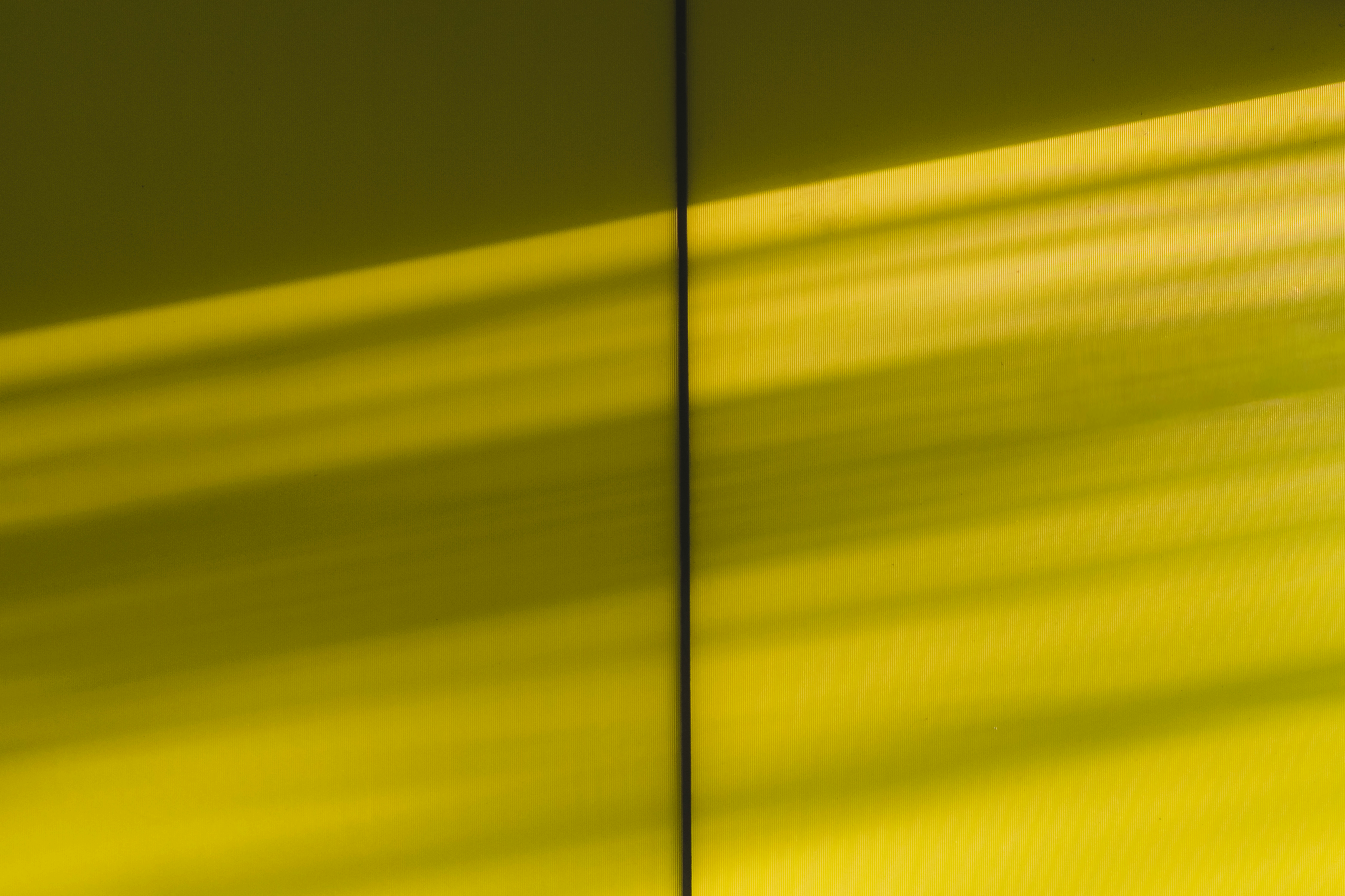 Sunlight stripes on a yellow wall