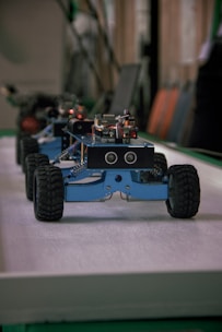 Several blue robotic vehicles with wheels lined up.