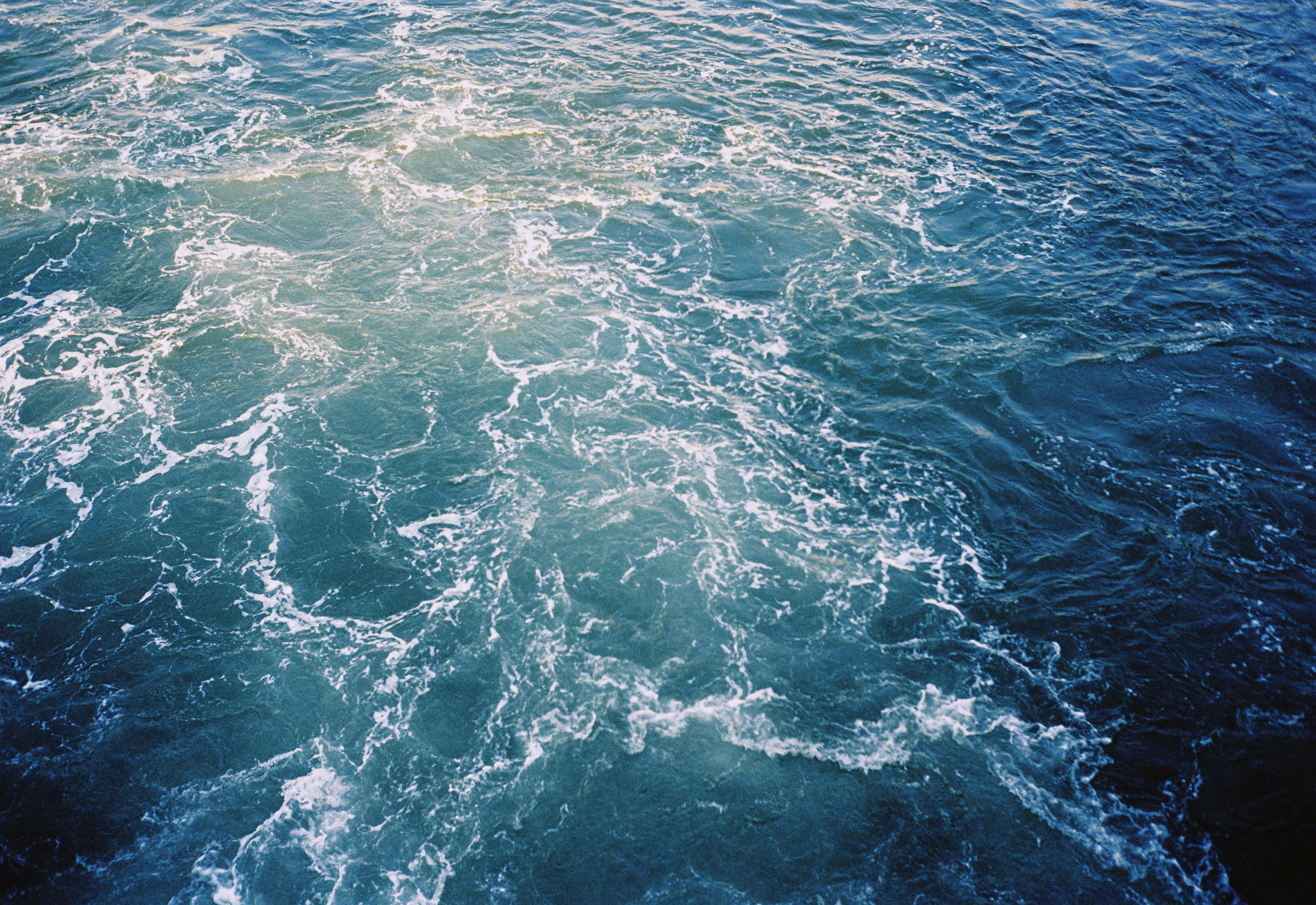 Churning blue water with white foam patterns