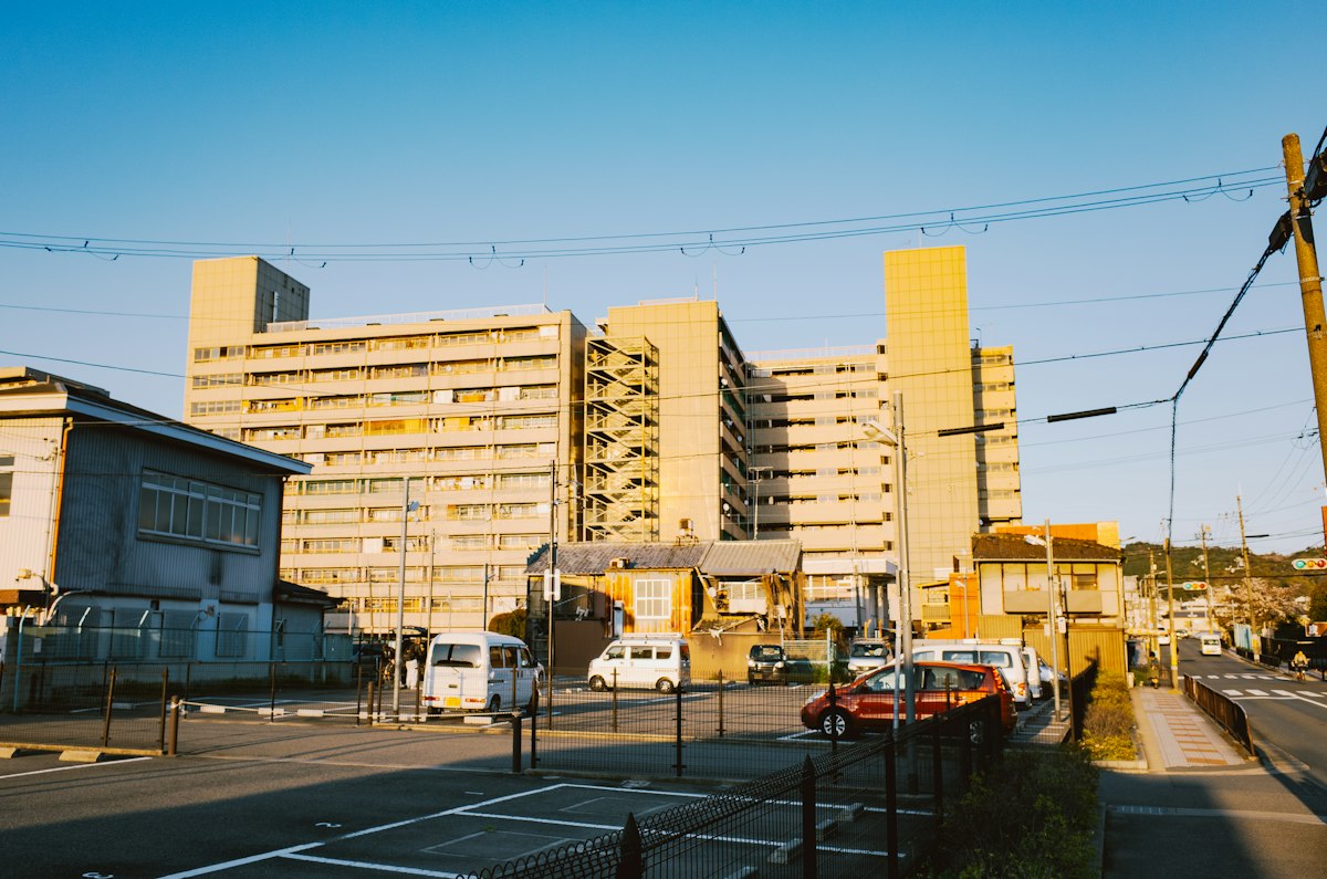 駐車場の奥に並ぶ中層の集合住宅
