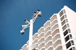 Security cameras mounted on a pole near a building.
