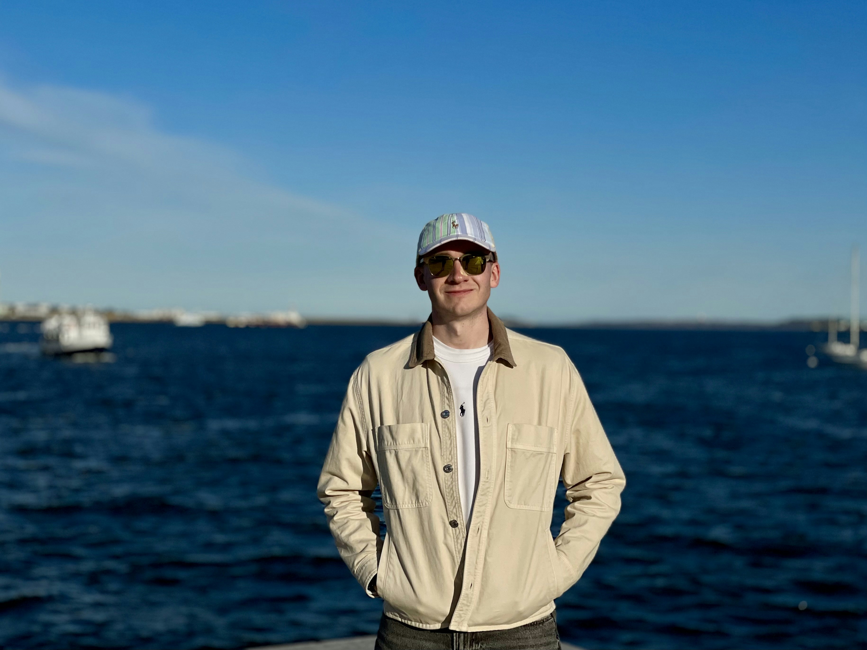 Man in cap and jacket by the ocean