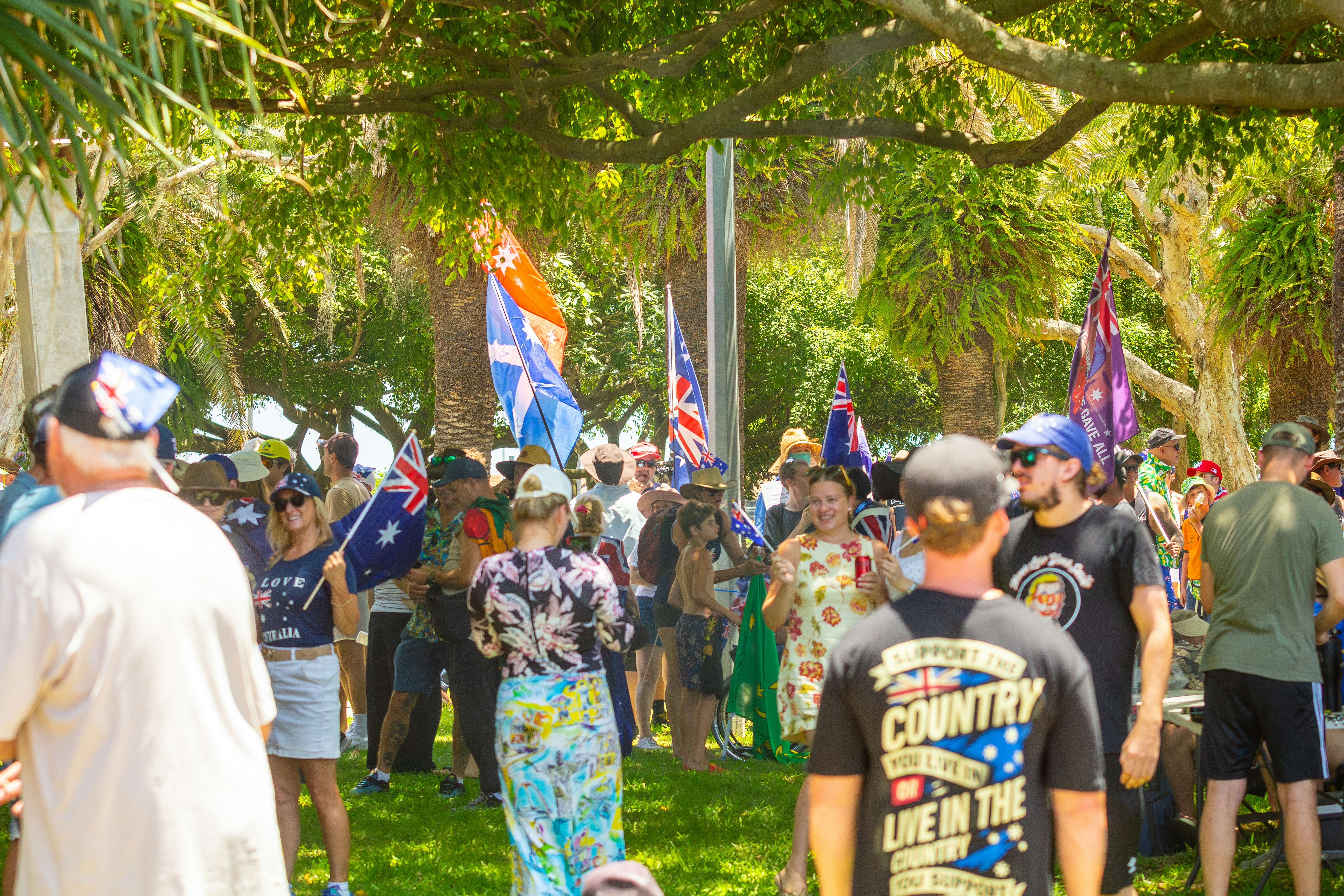 Crowd of people holding australian flags outdoors