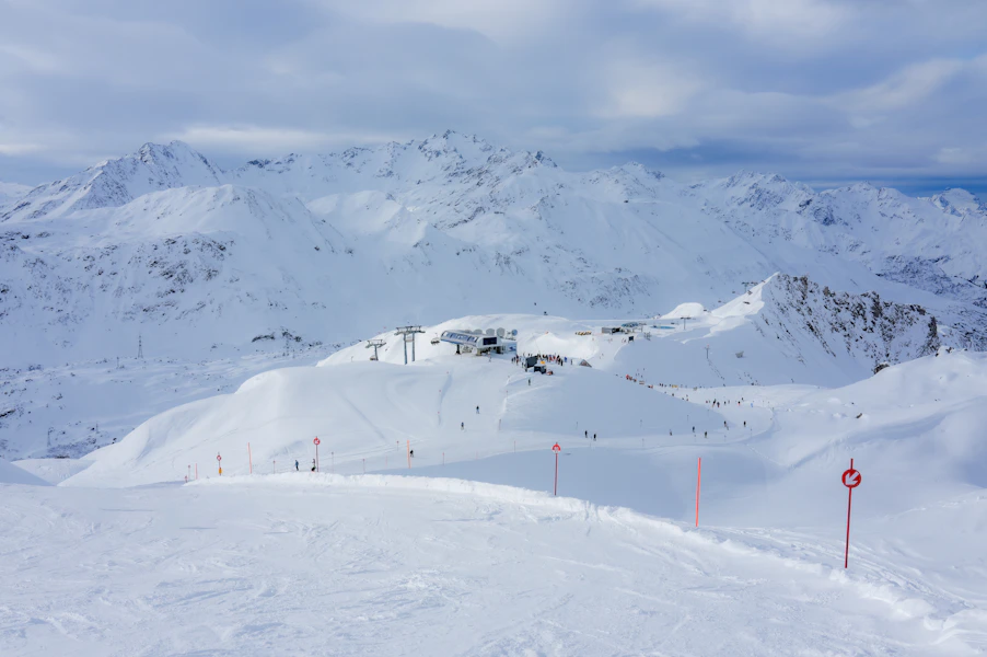 Snowy mountain landscape with ski slopes and lifts under blue sky