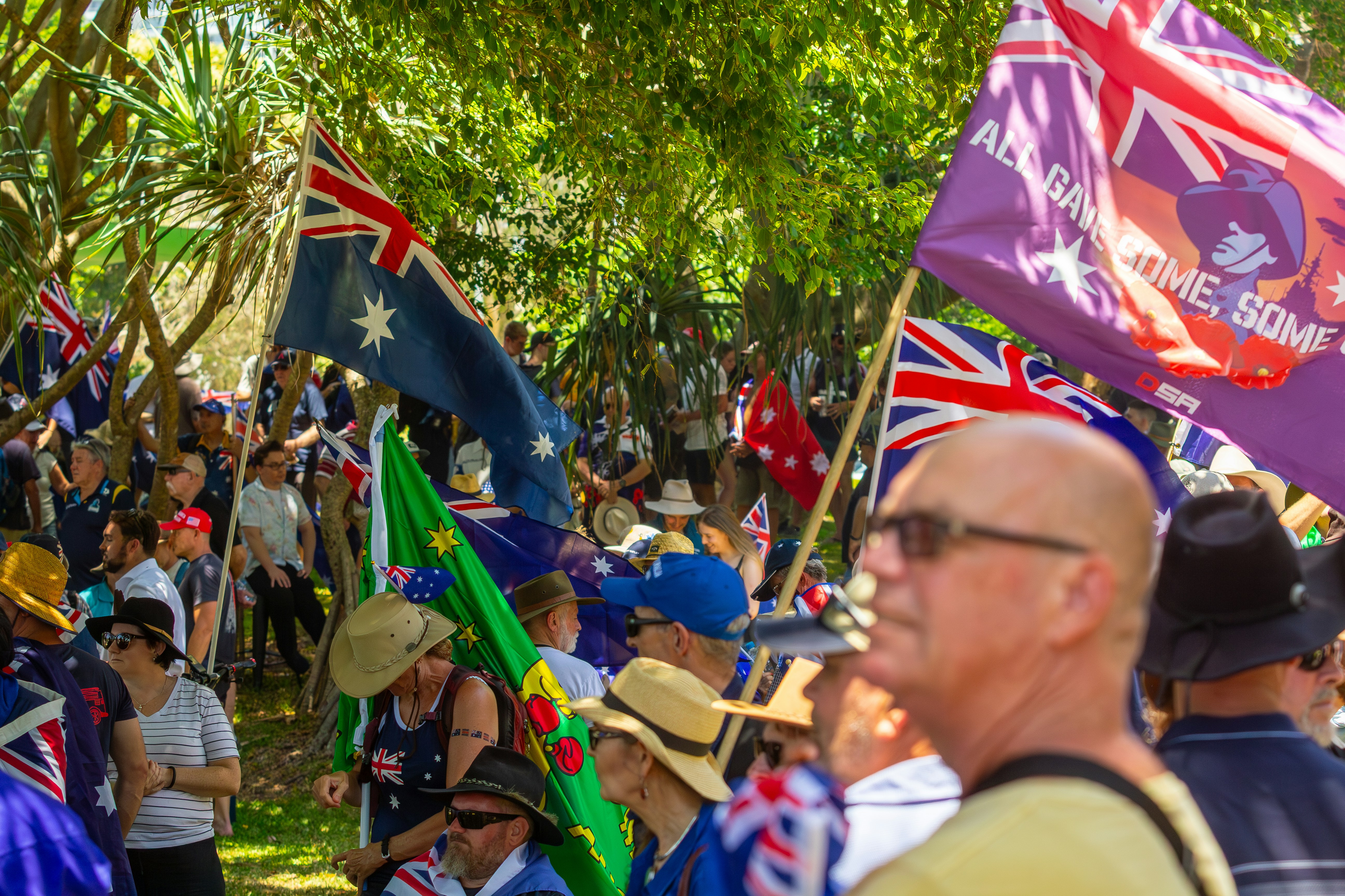 Multitud ondeando banderas australianas en un evento al aire libre.