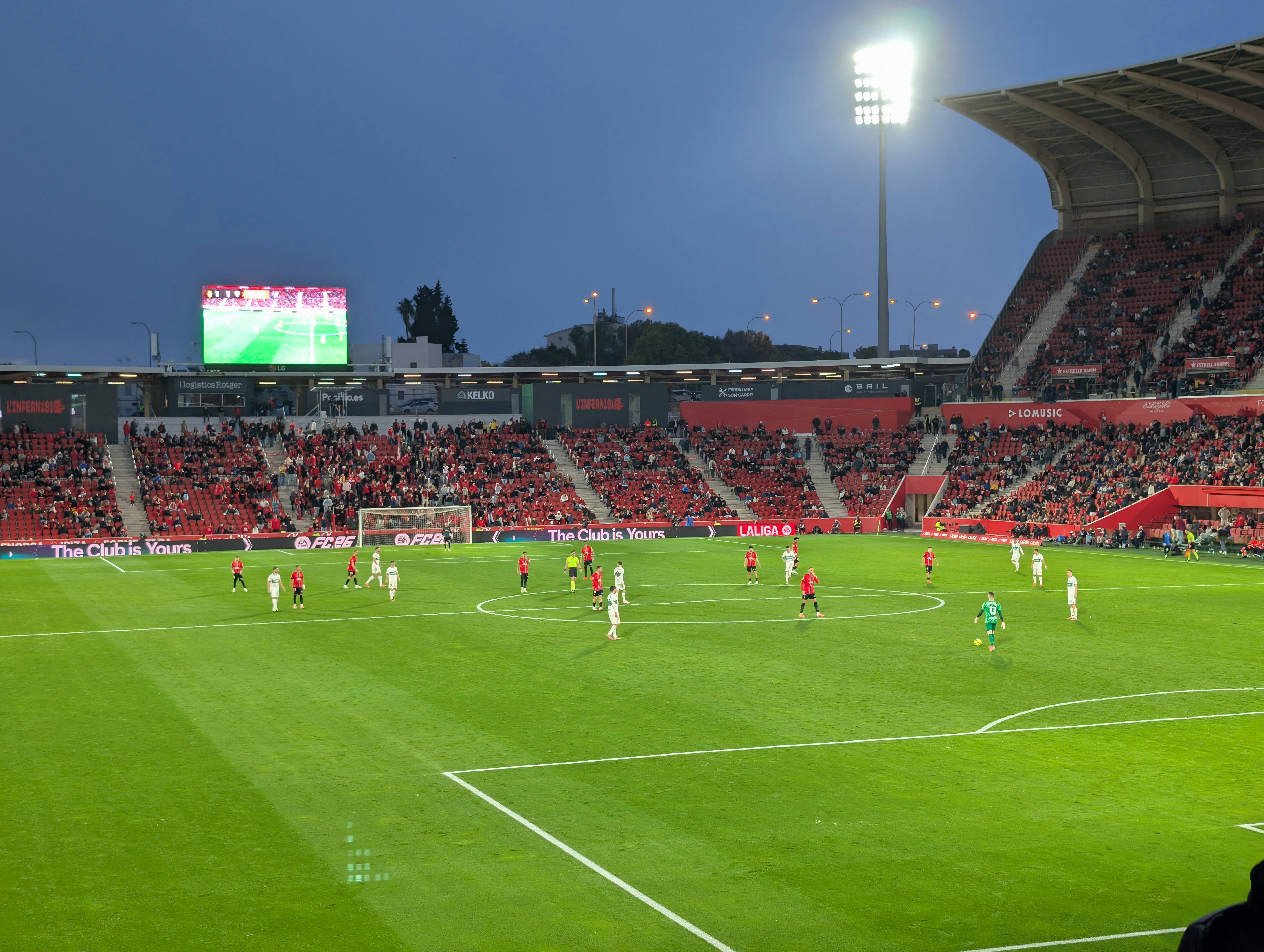 Tribunas encendidas en un estadio europeo durante un partido nocturno