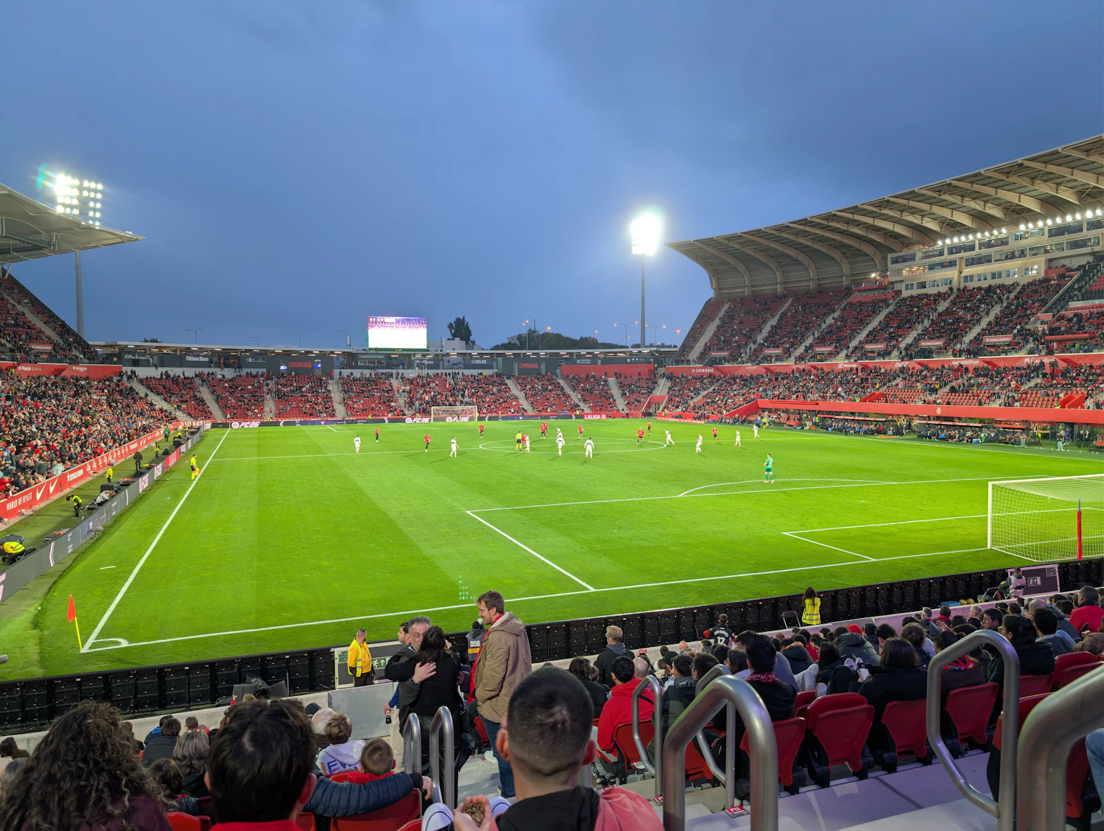 A professional football match in a floodlit stadium