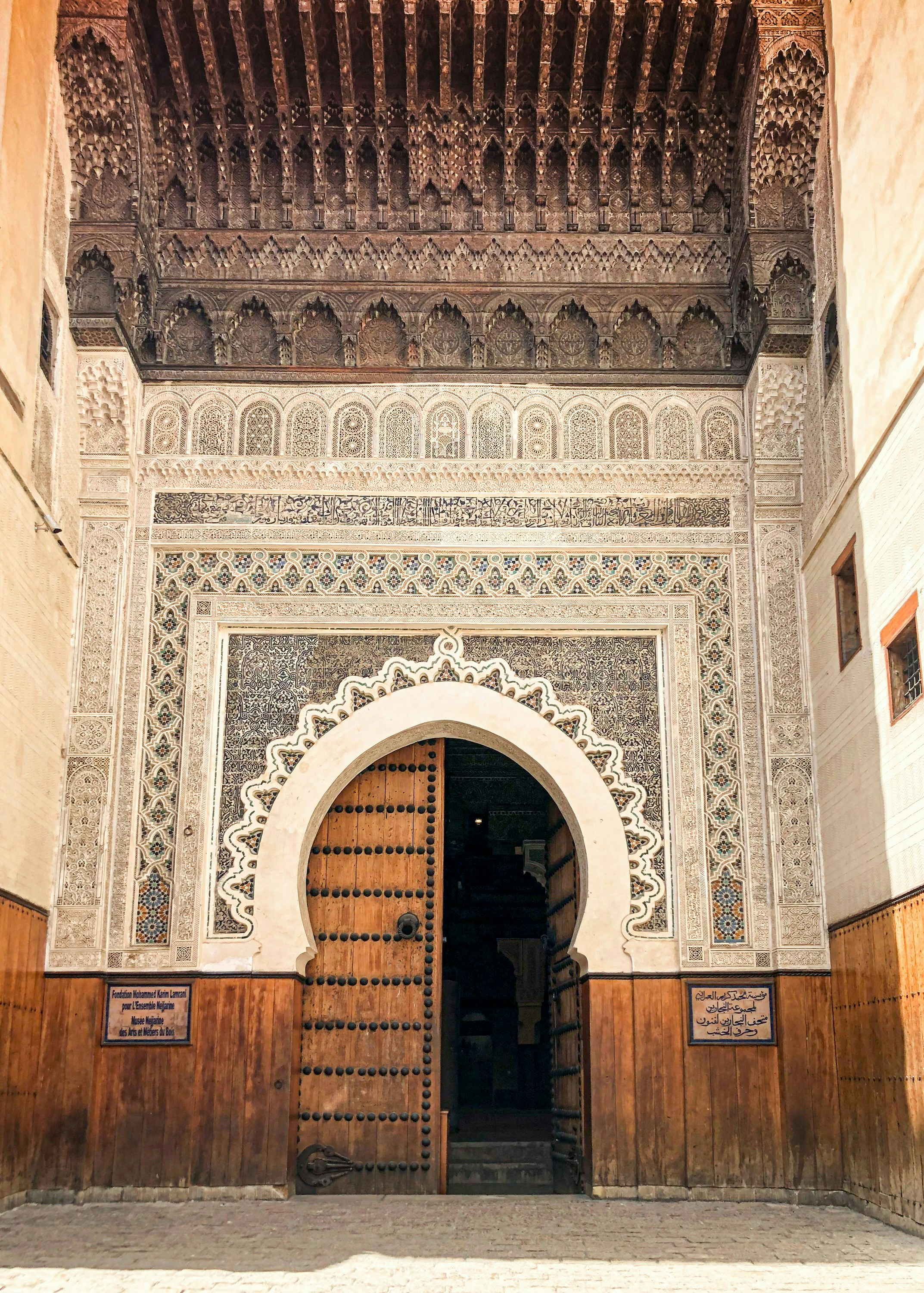 Ornate arched doorway with intricate carvings and wooden door.