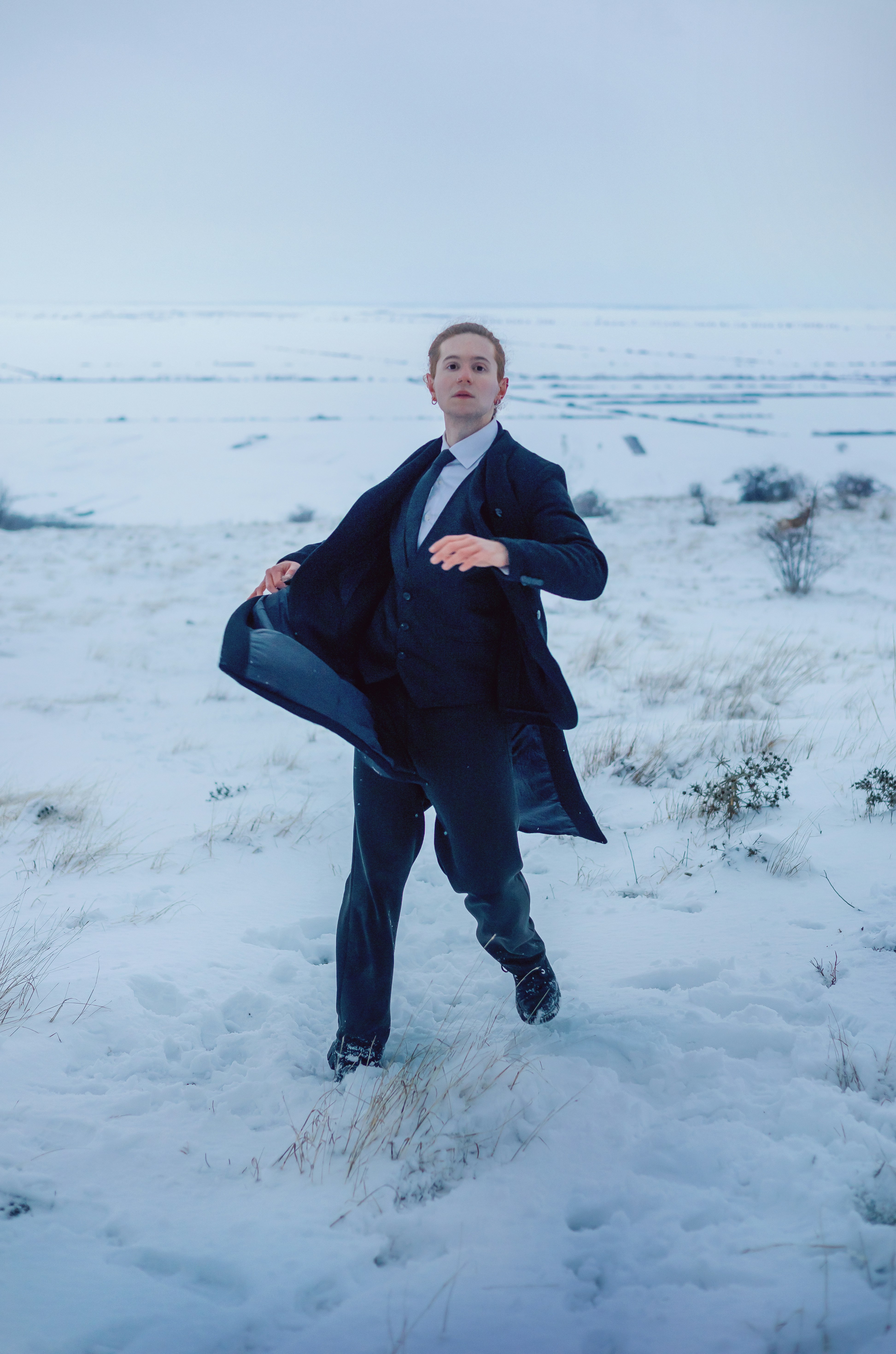 Homem de terno correndo por uma paisagem nevada
