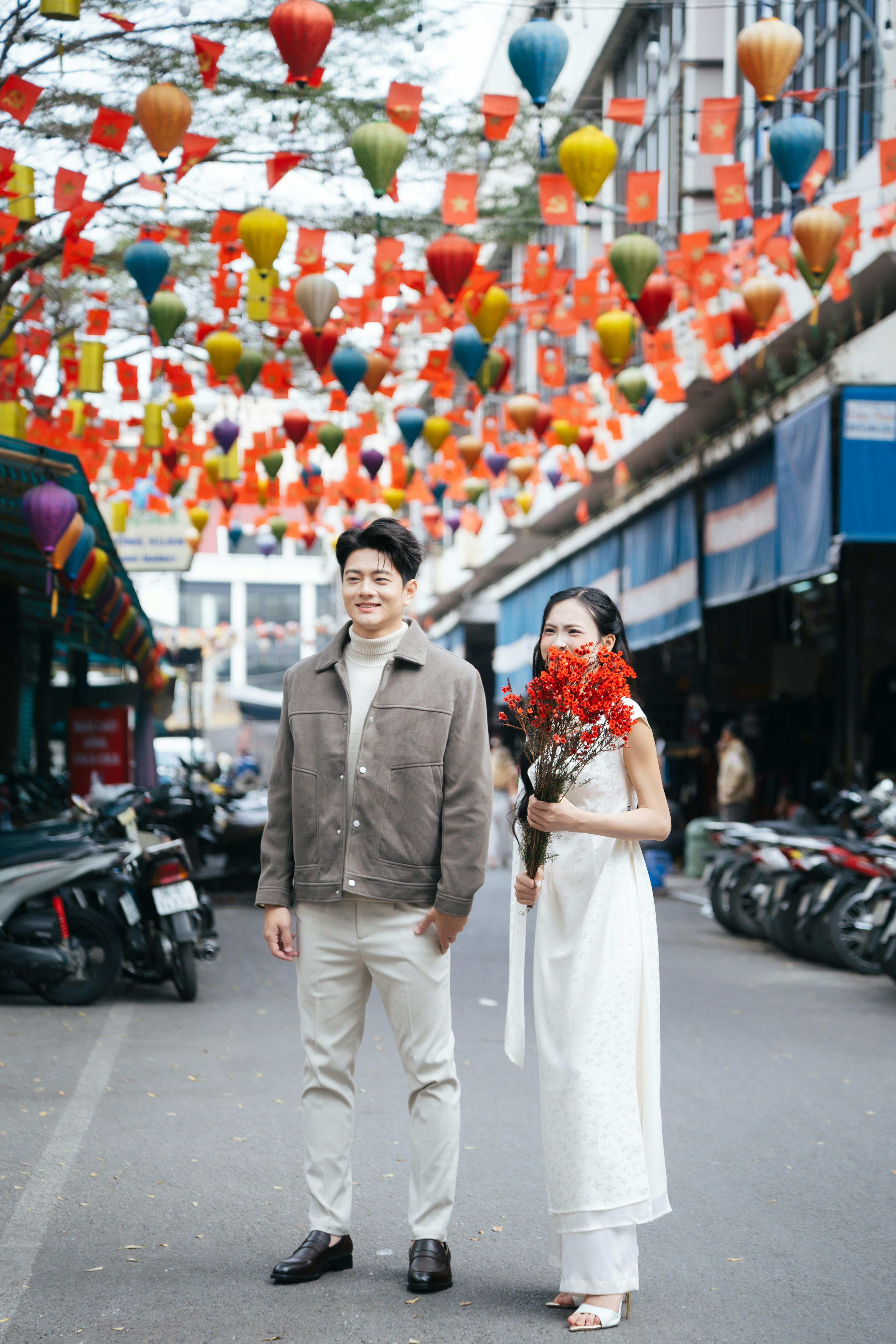 Couple standing on a street decorated with lanterns