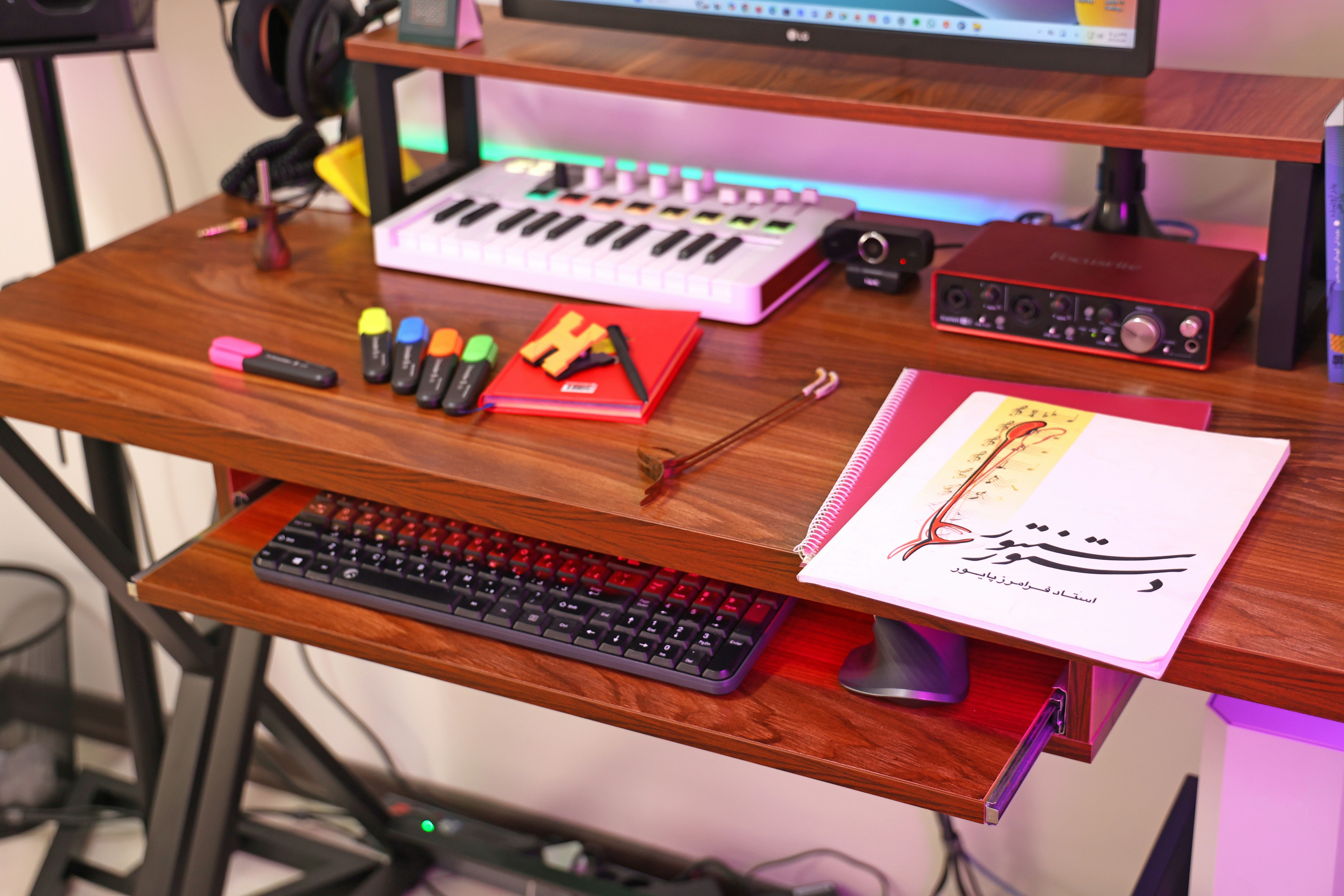 A music production desk with keyboard and audio interface.