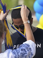 Man receiving a medal with yellow and blue ribbon