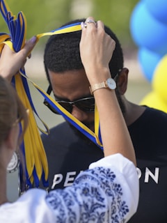 Man receiving a medal with yellow and blue ribbon