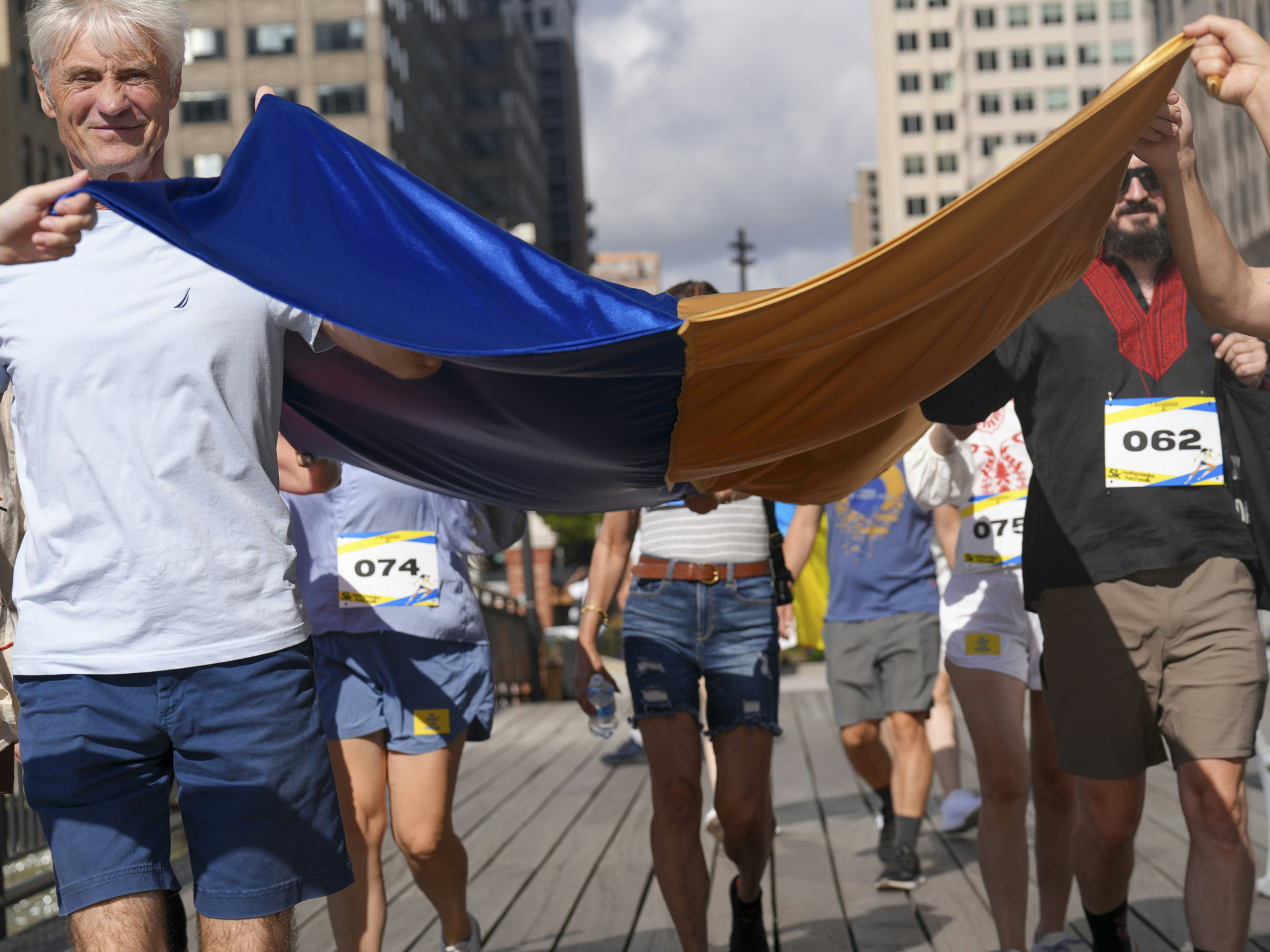 Orang-orang memegang bendera biru dan kuning besar