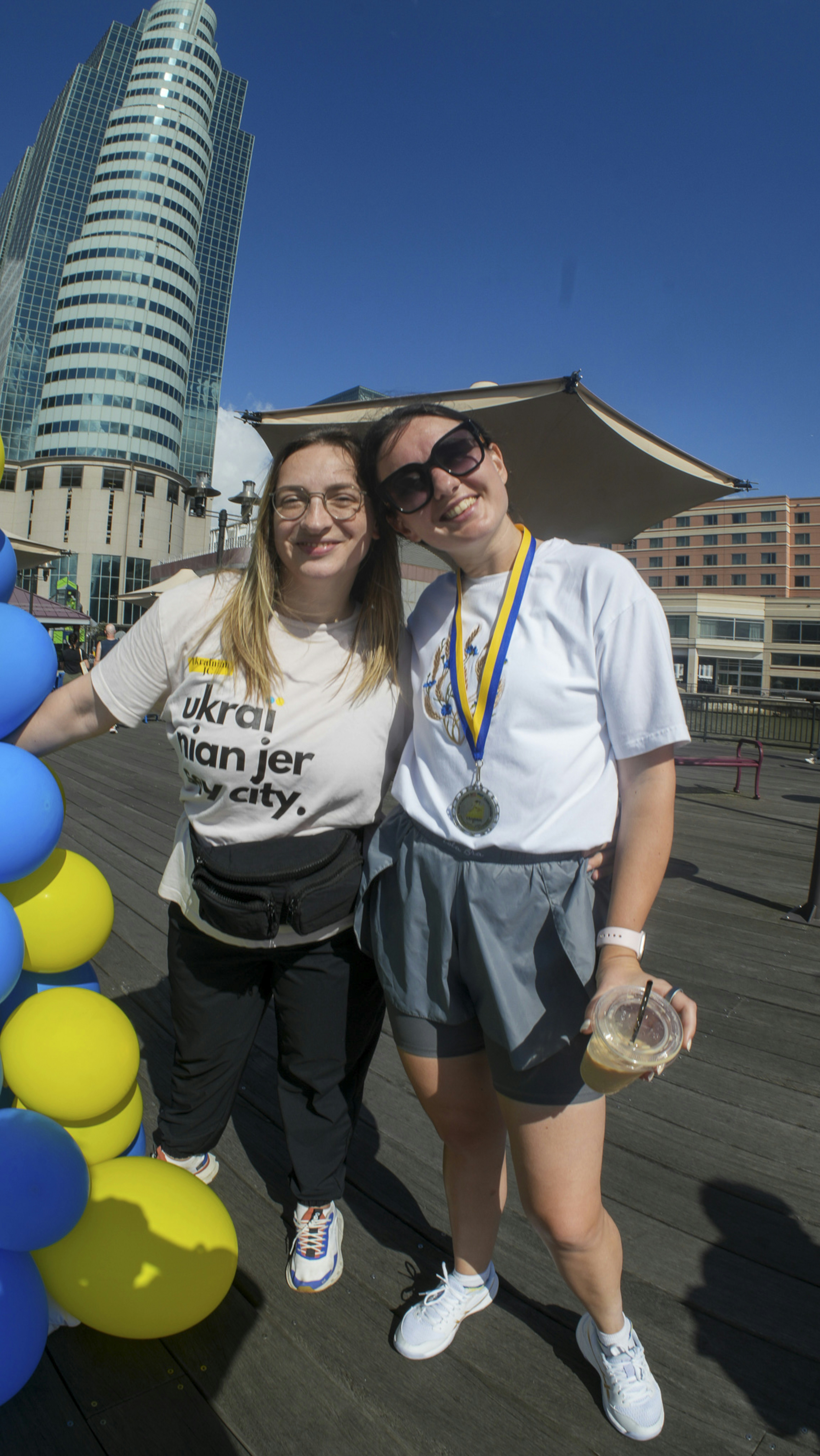 Two women with ukrainian flags and medals
