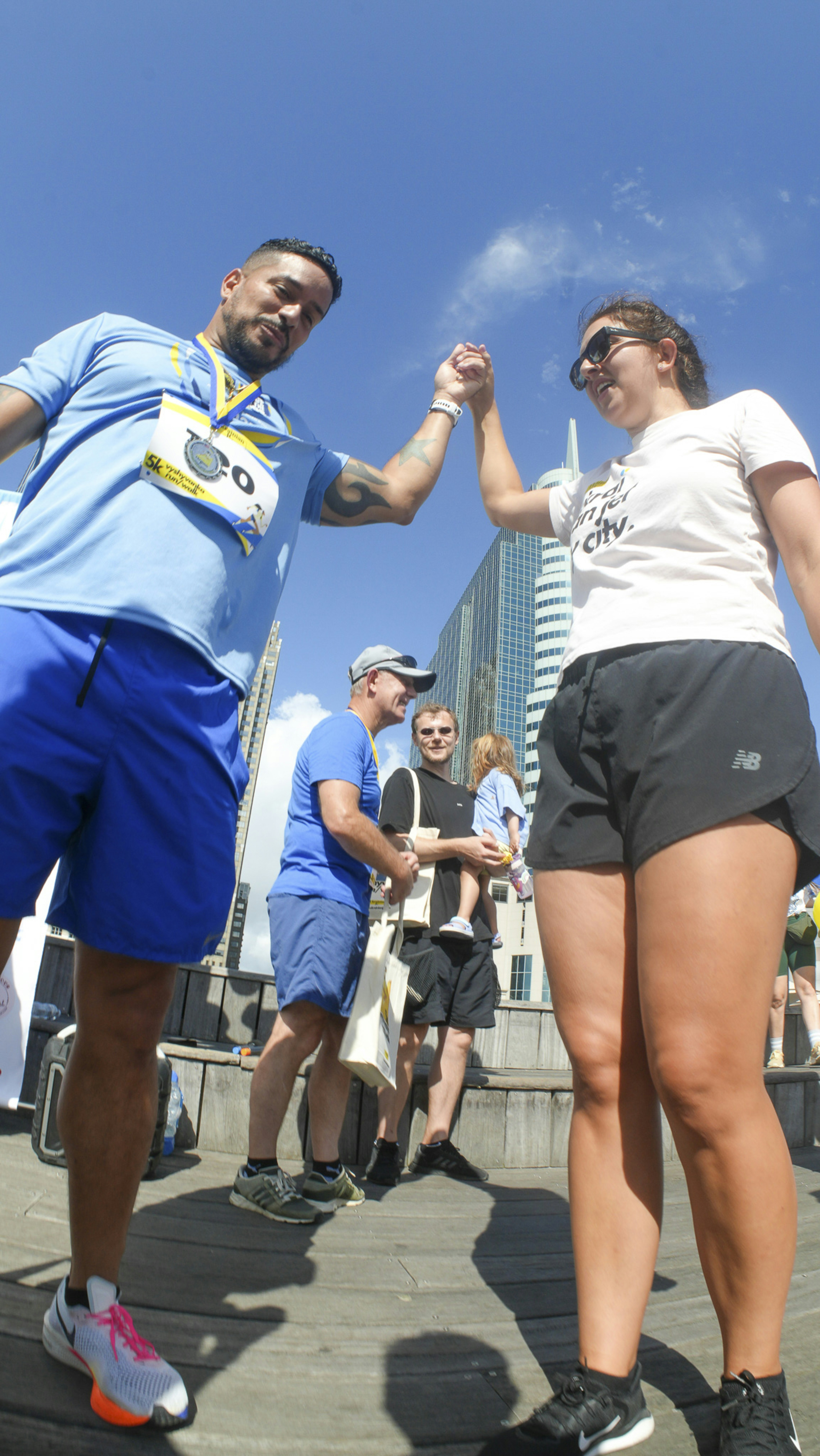 Two runners high-five after a race.