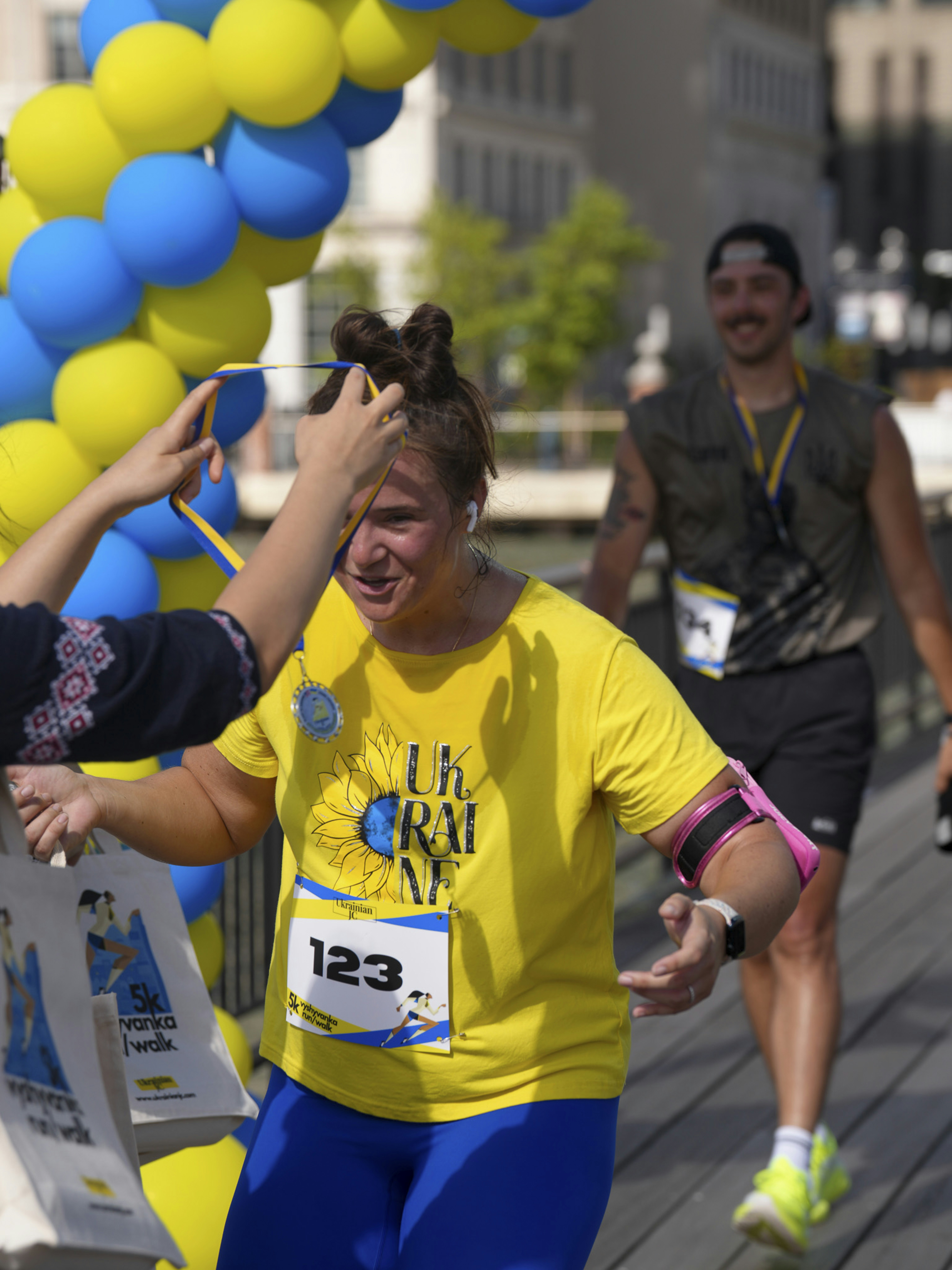Runner in yellow shirt with ukraine sunflower logo