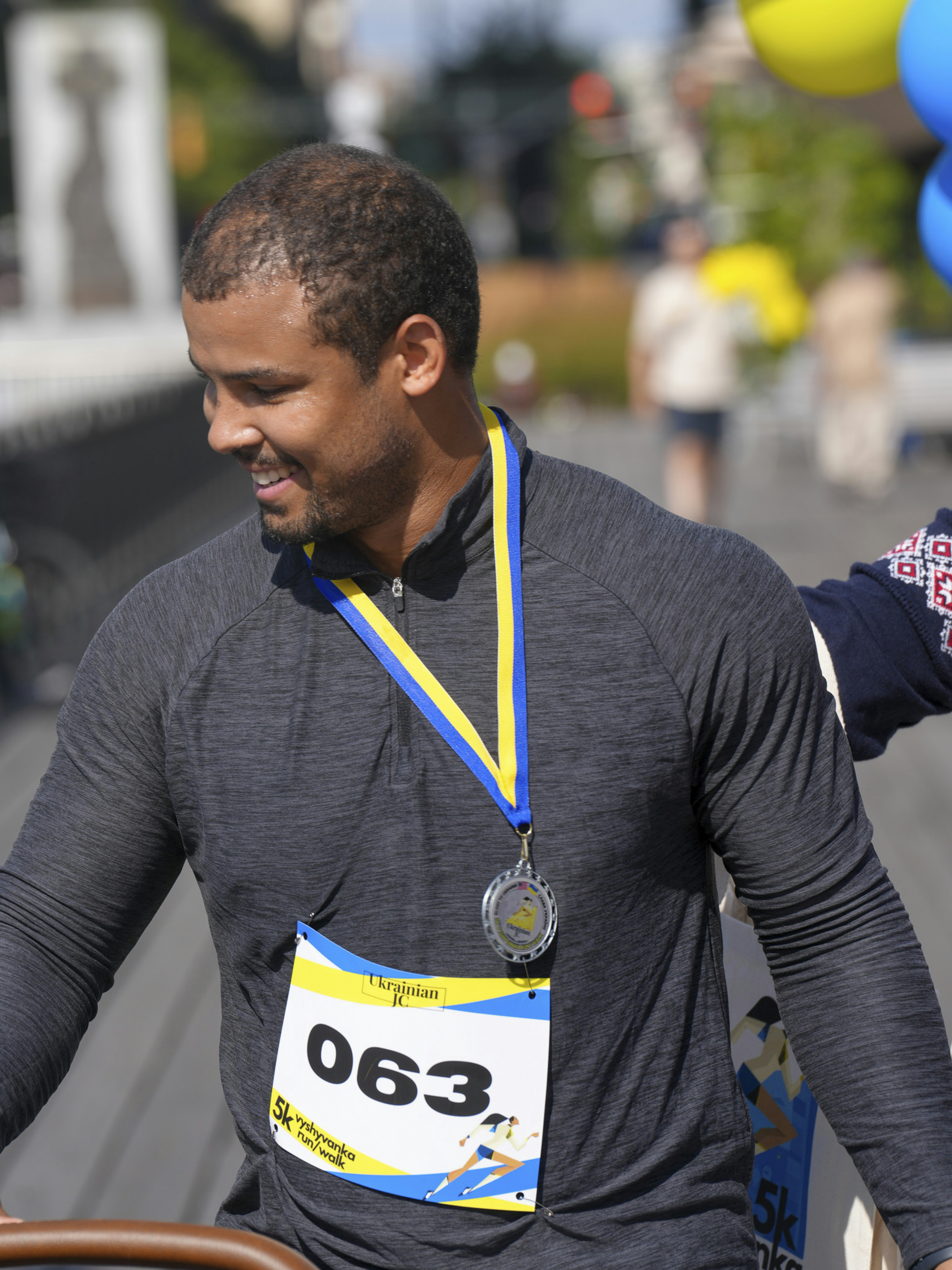 Man wearing a medal and bib number 063