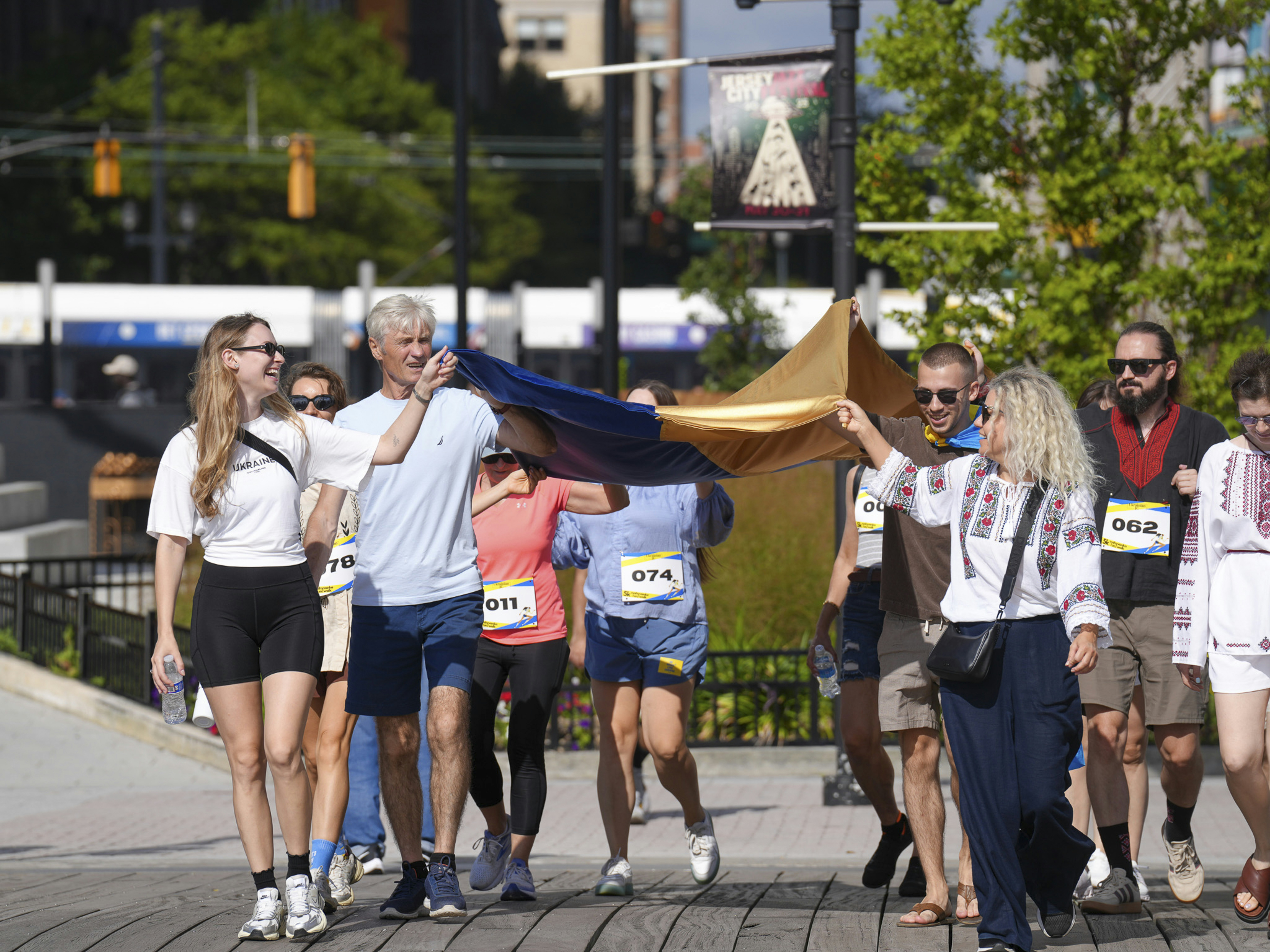 People carry a large ukrainian flag during a race.