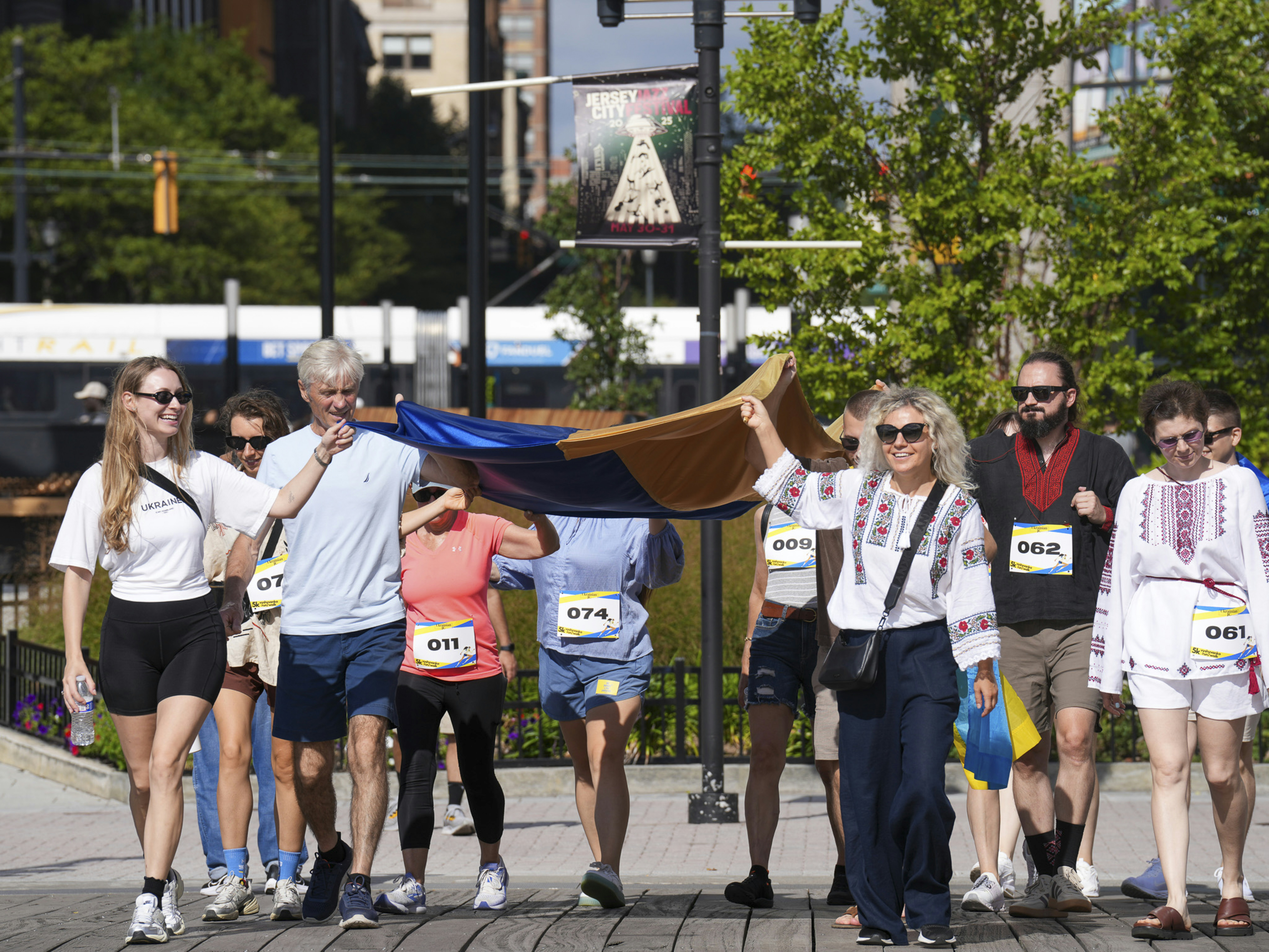 People carry a large ukrainian flag during a race.