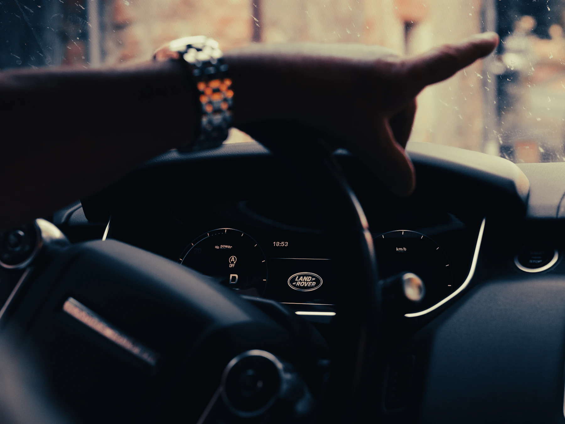 Driver using the steering wheel inside a premium vehicle during a journey