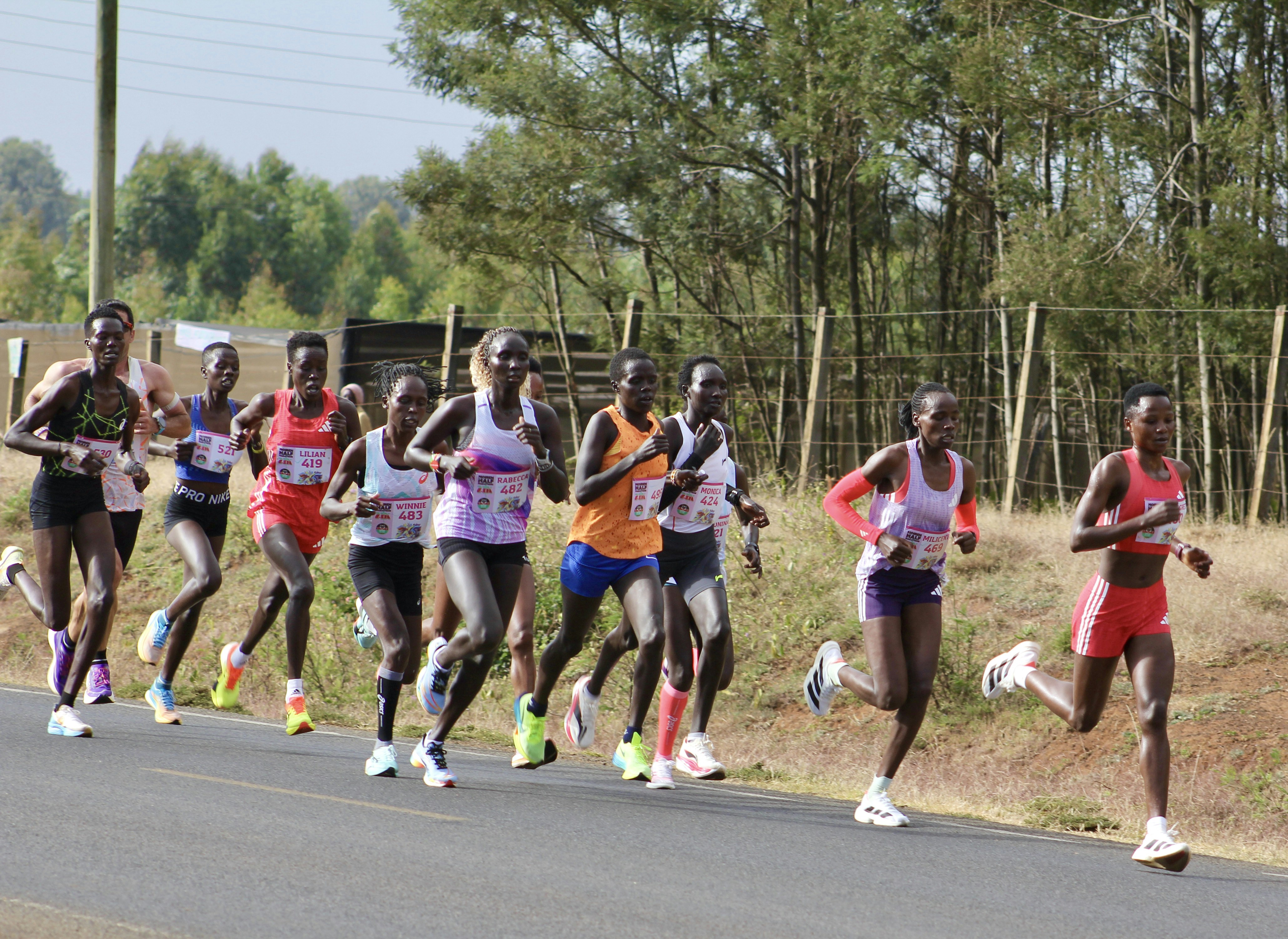 Athletes running a marathon on a paved road.