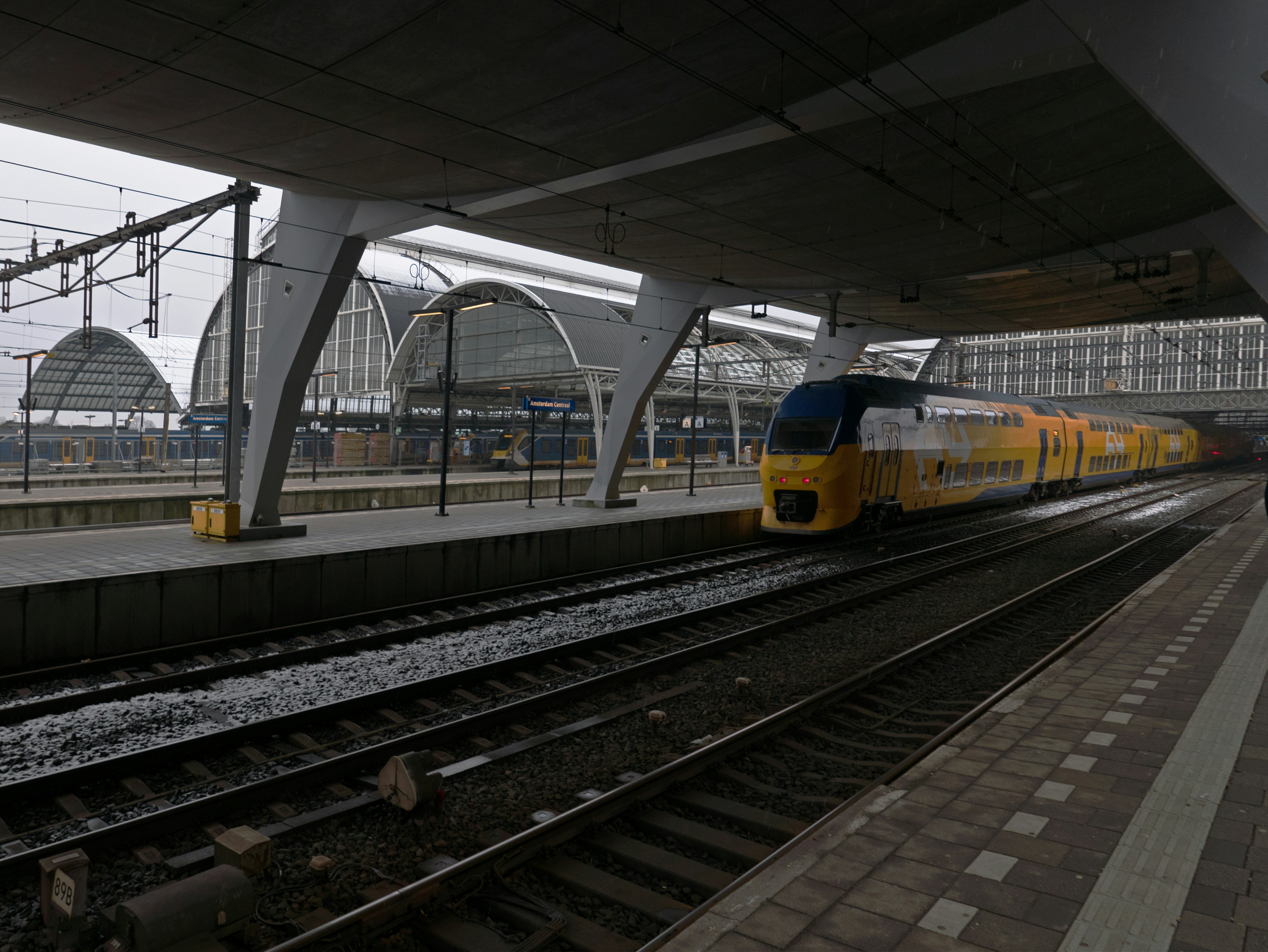 A yellow train at a modern station platform.