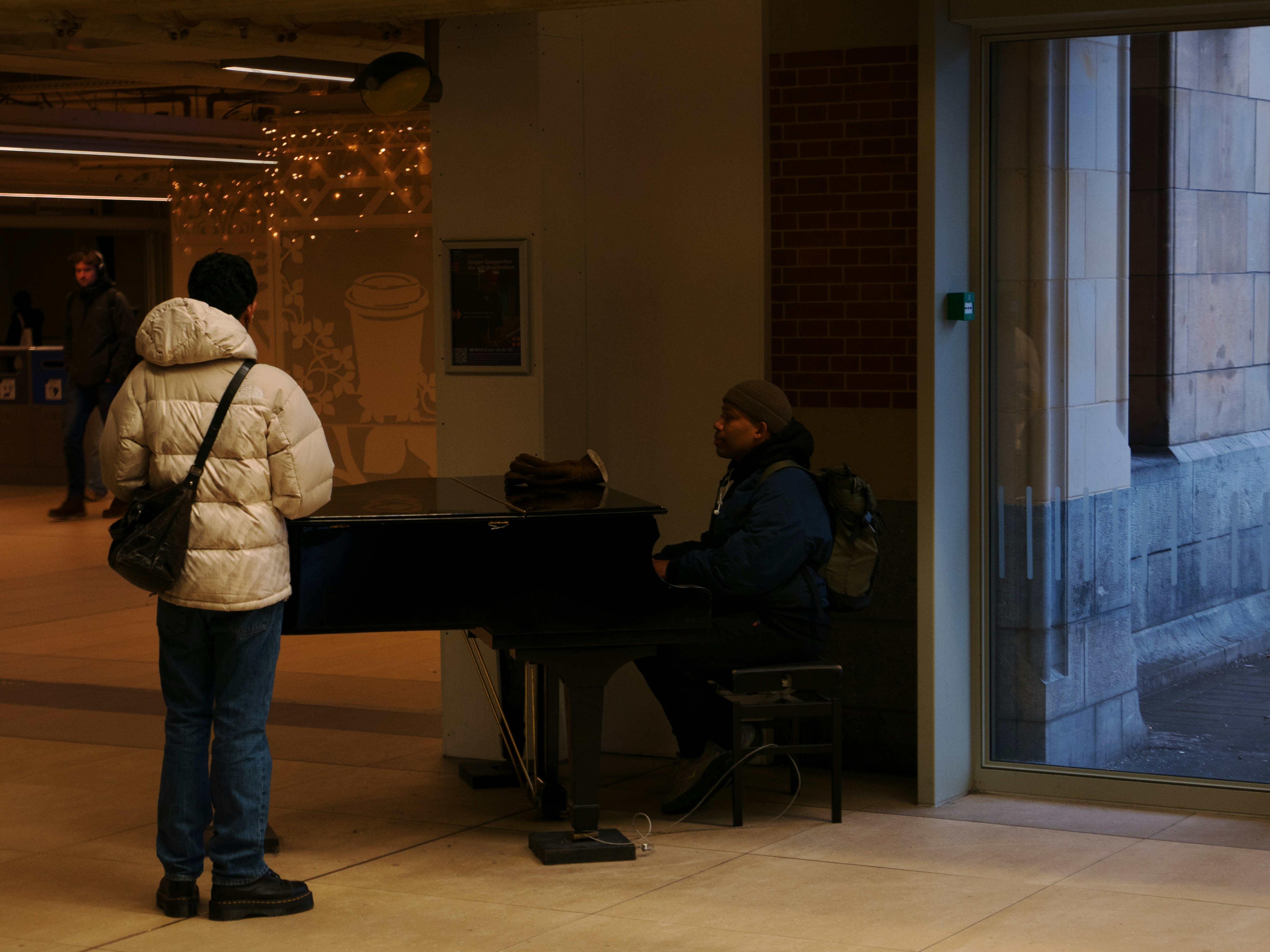 Person plays piano while another person watches