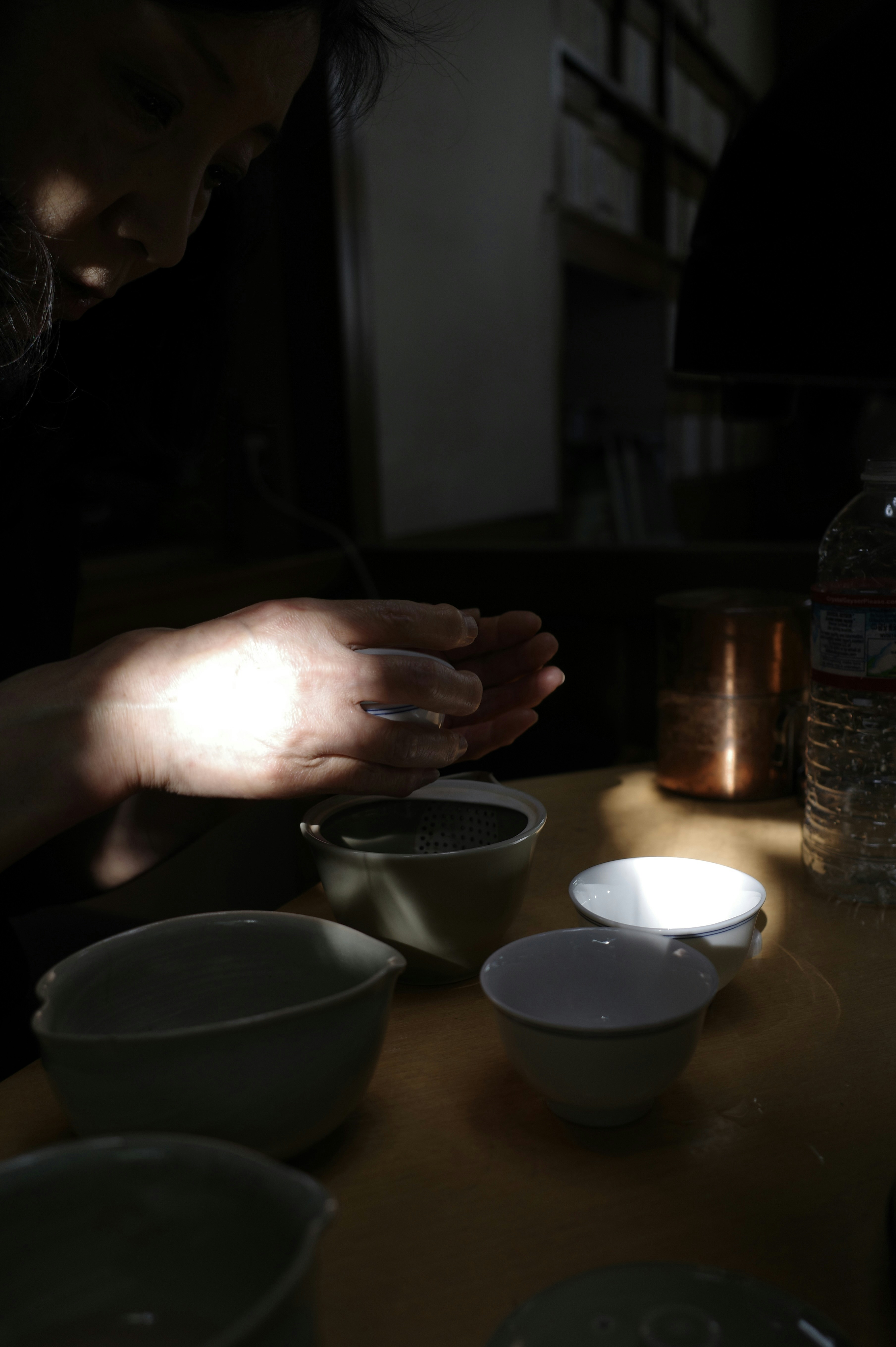 A person's hands holding white powder over bowls.