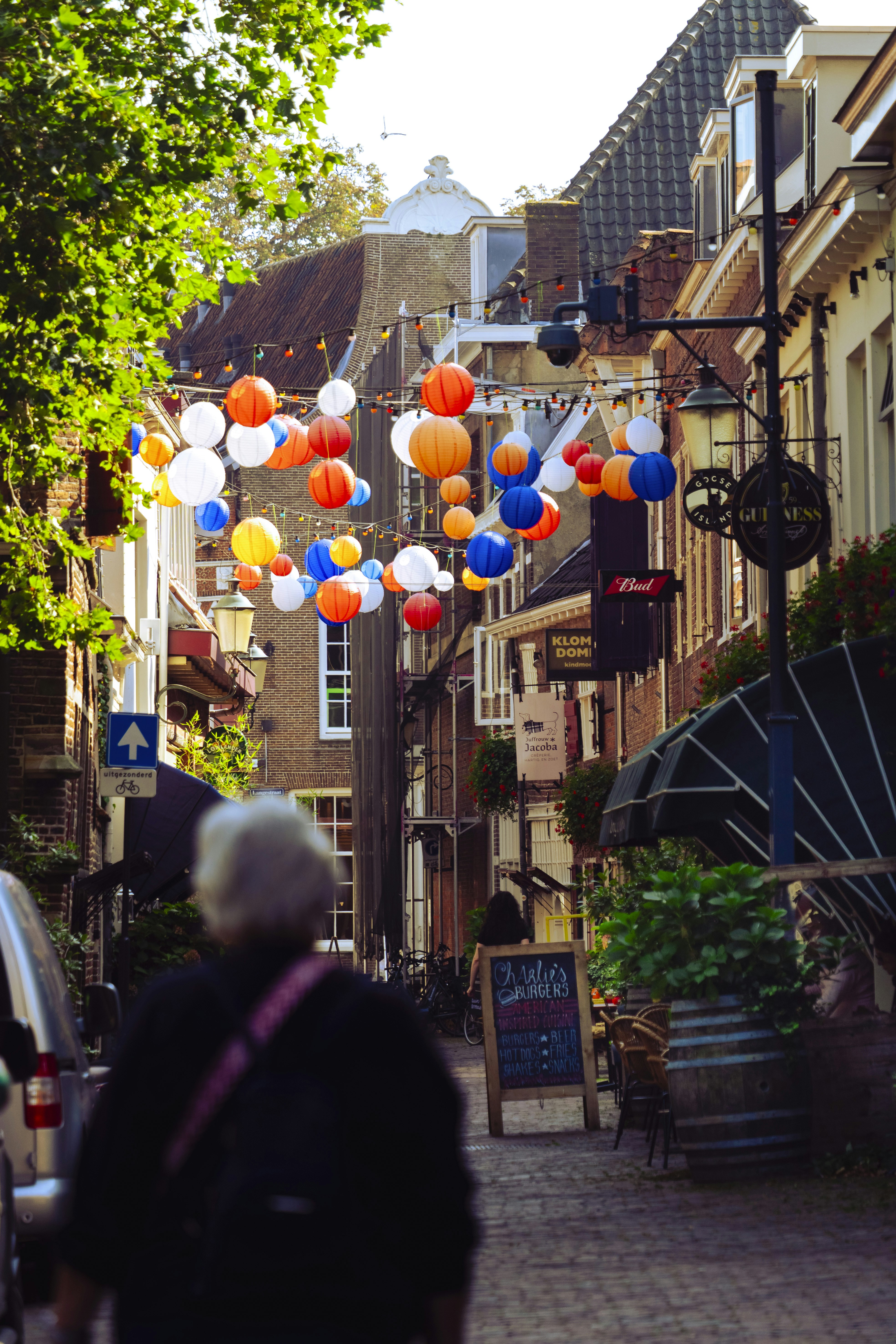 Colorful lanterns strung across a charming european street.